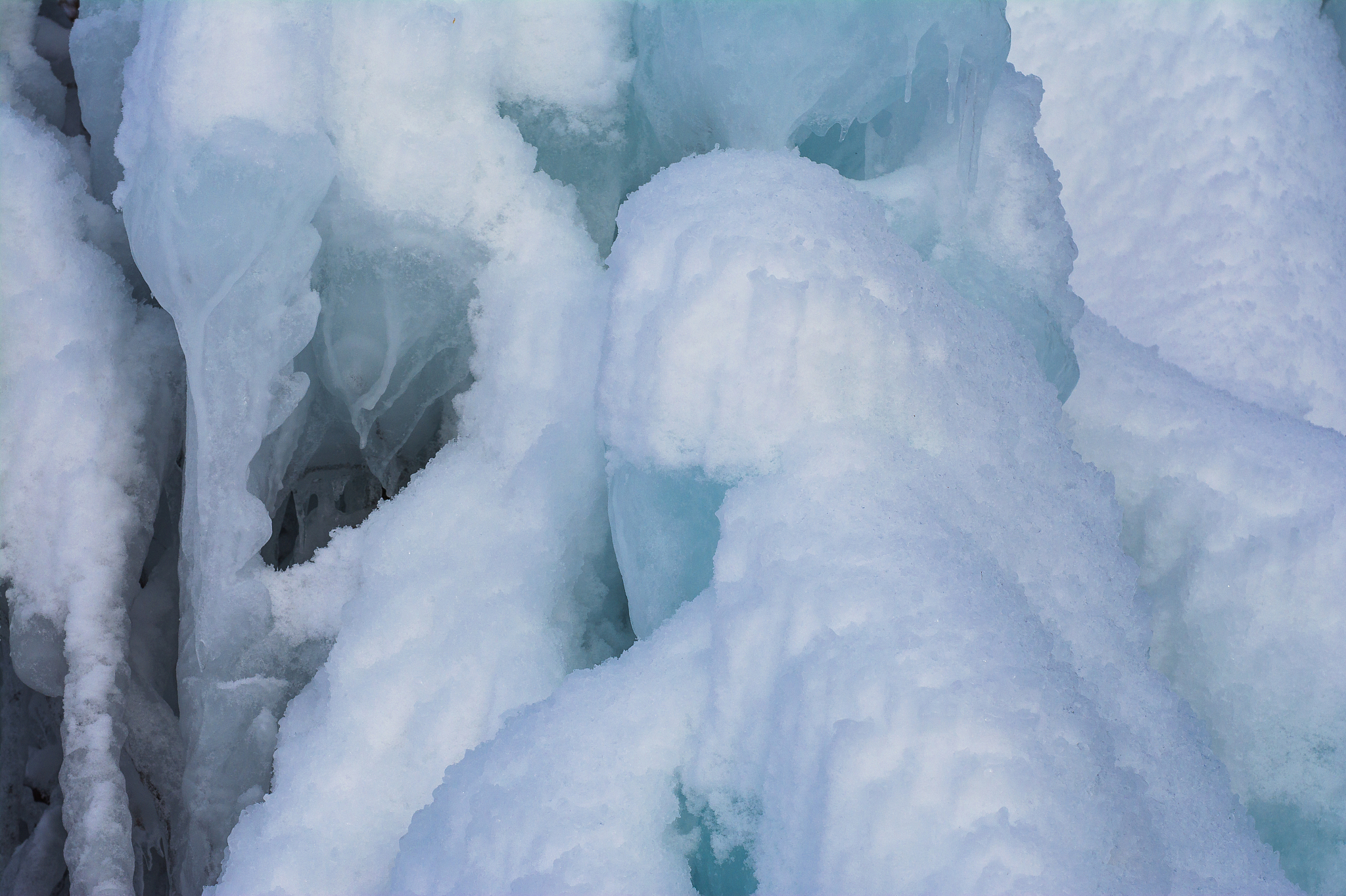以SCI标准翻译：结果表明在考虑雪粒不规则外形的情况下雪粒在流场中受到的阻力较大不易跟随气流排出转向架区域停留在转向架区域的雪粒数量增加导致积雪量增加。在雪粒入射量缩放十倍的情况下转向架各部件的积雪量相应缩放十倍因此可在计算资源匮乏的情况下合理选择雪粒入射量进行规律性研究。在横风环境下由于气流能直接冲击转向架表面导致转向架区域整体流速提升且壁面剪切速度增加雪粒能稳定沉积的概率降低所以积雪主要发生在