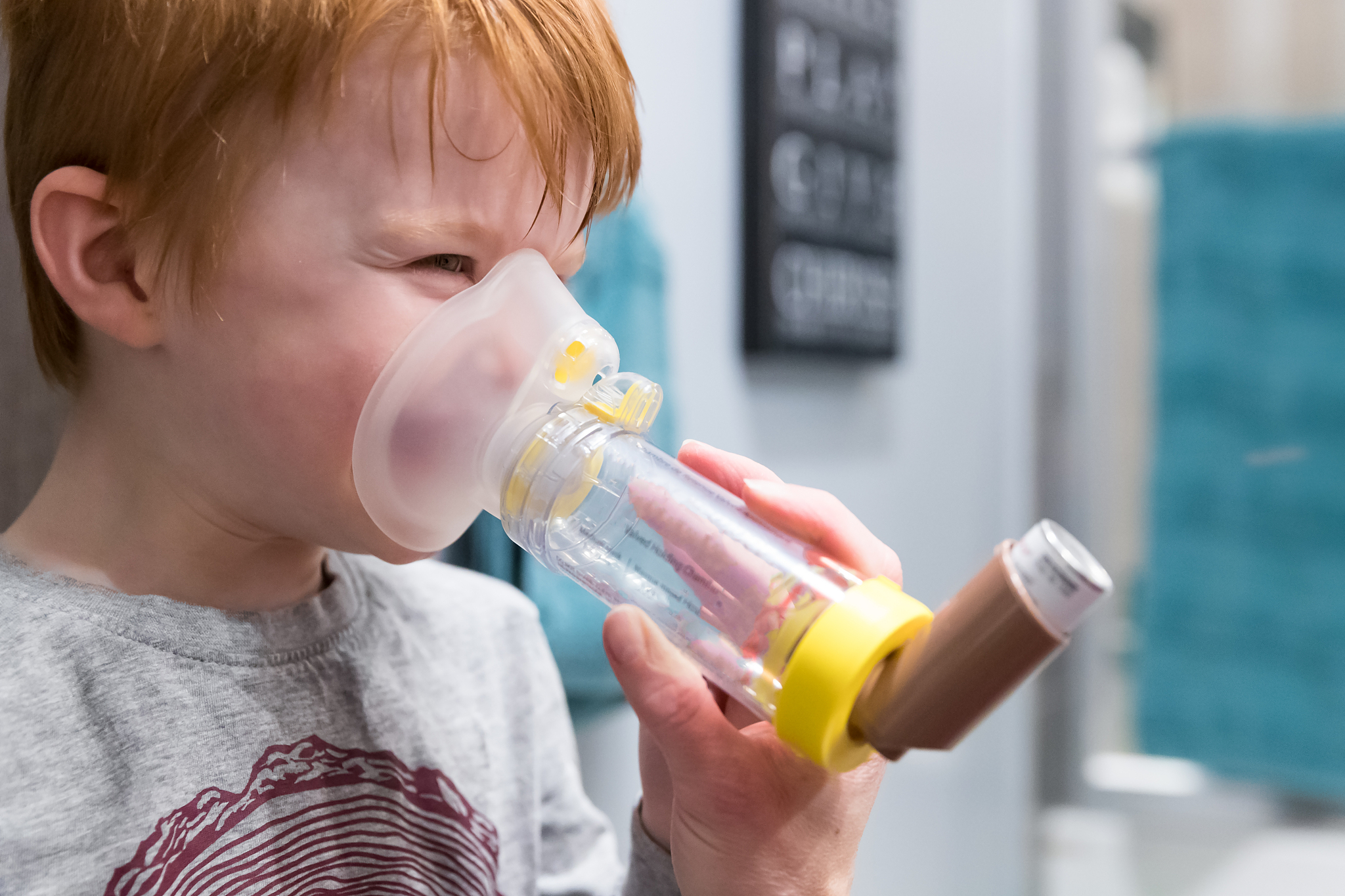 young boy getting breathing treatment from mother