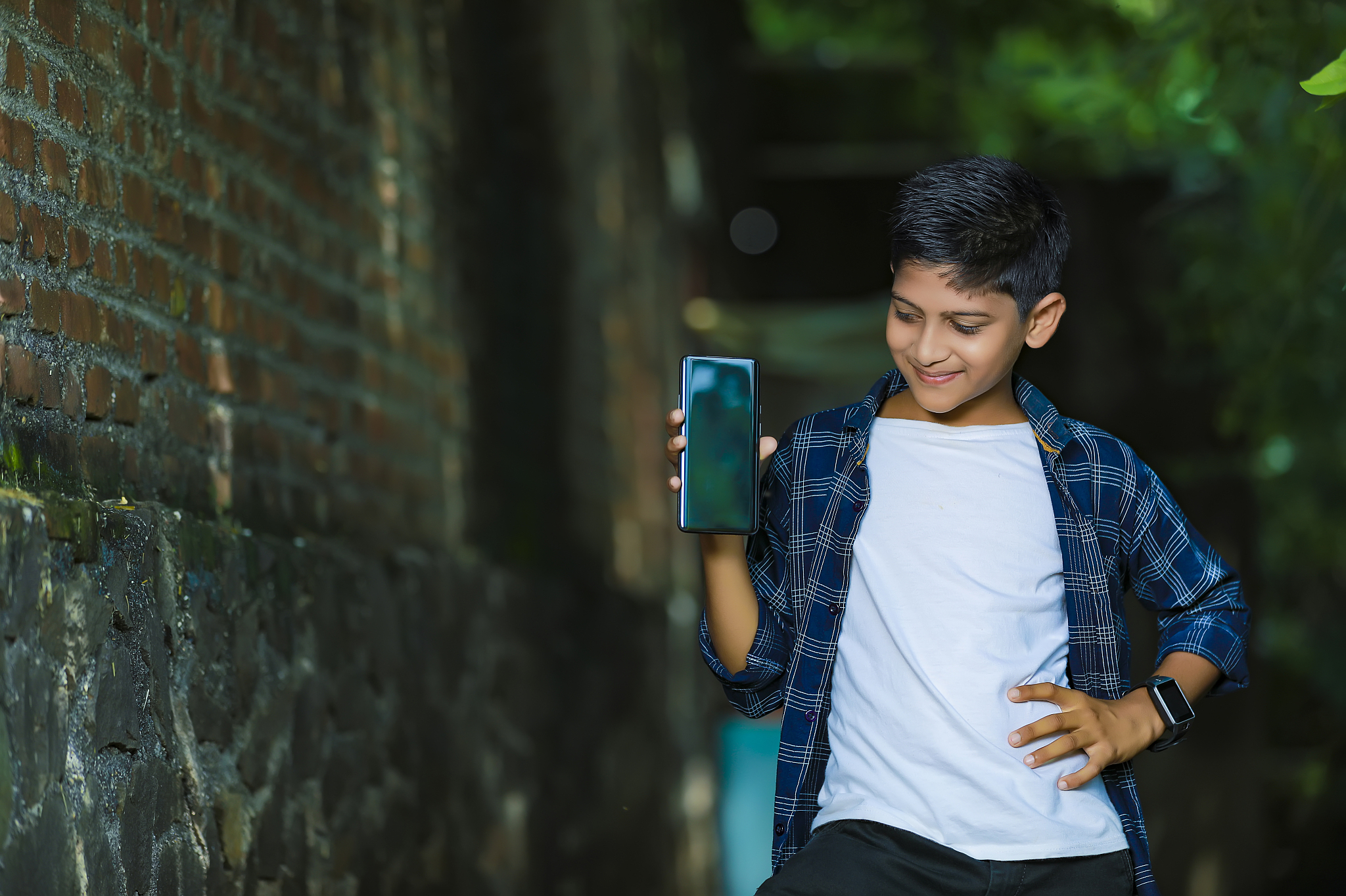 technology and people concept - smiling teenage boy in blue shir