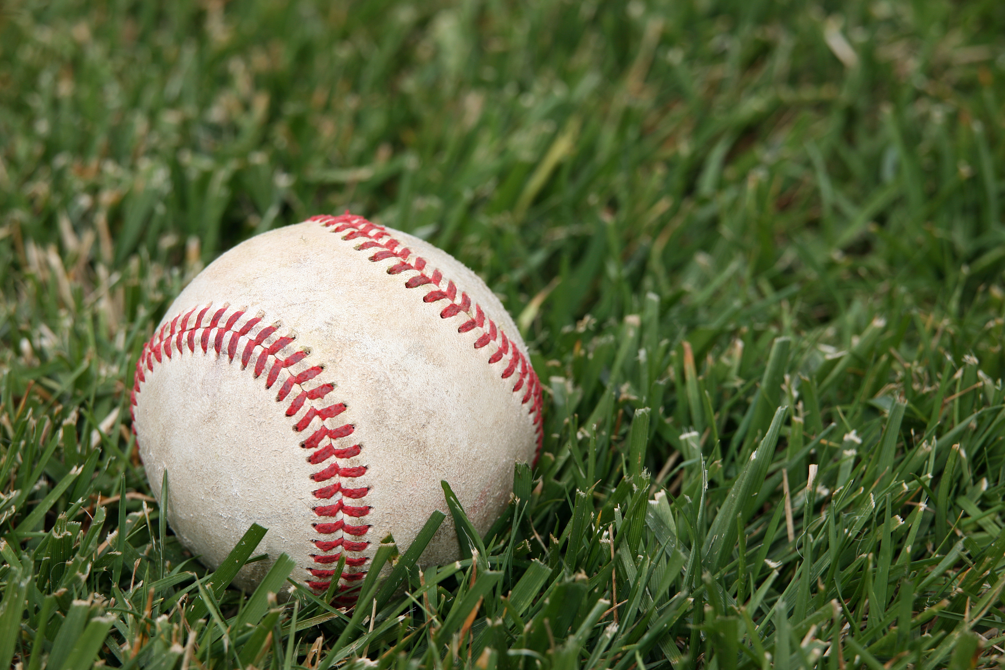 worn baseball on grass field