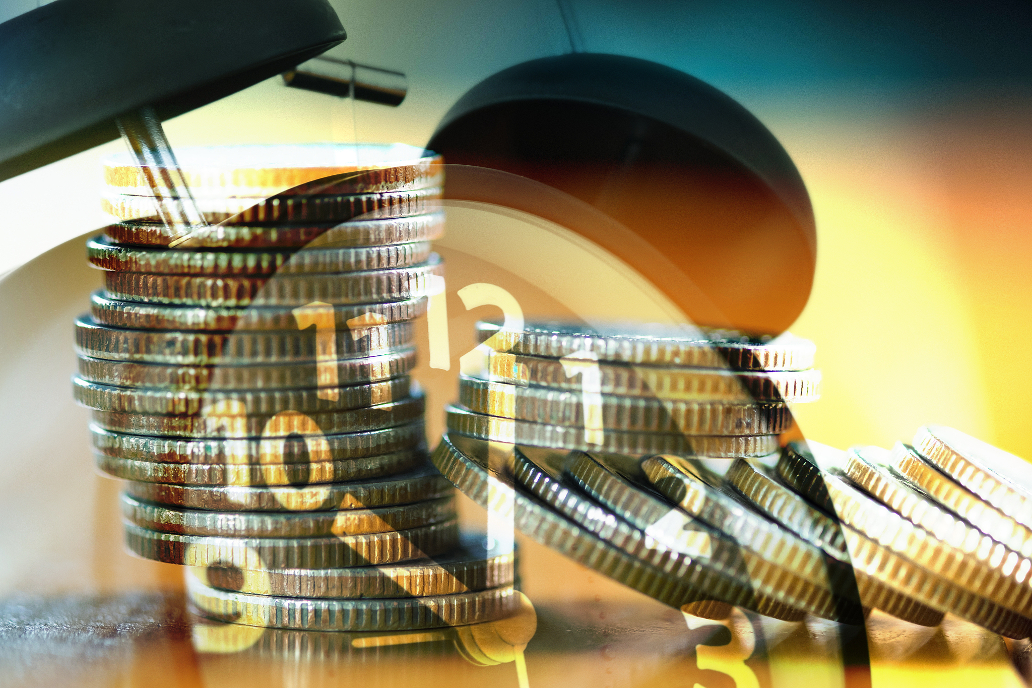 double exposure stacks of coins on working table with alarm cloc