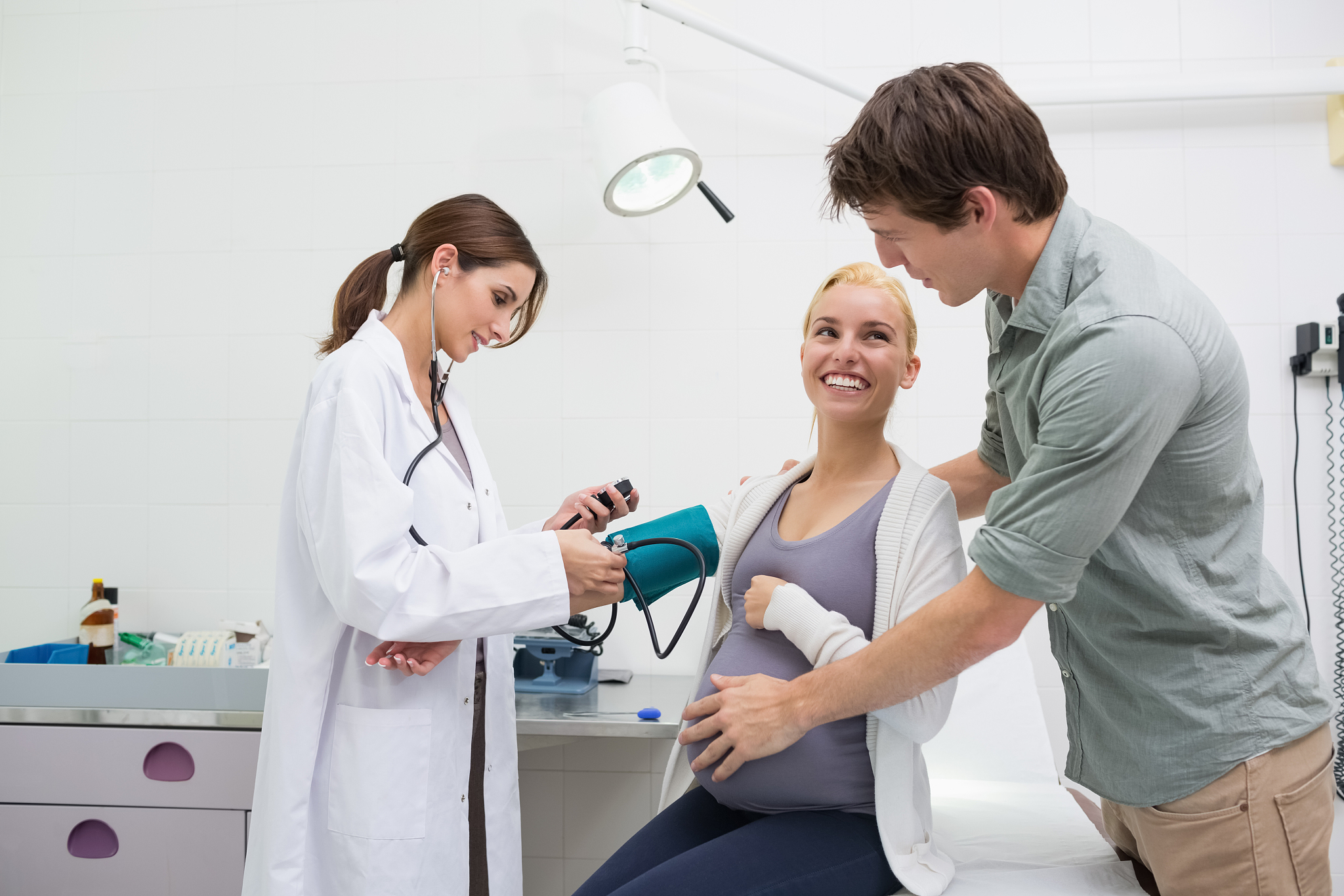 female doctor taking the blood pressure of a pregnant patient