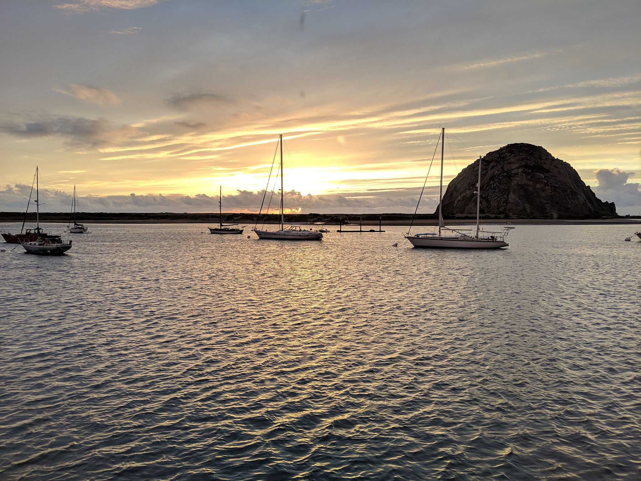 sailboats moored on sea against sky during sunset