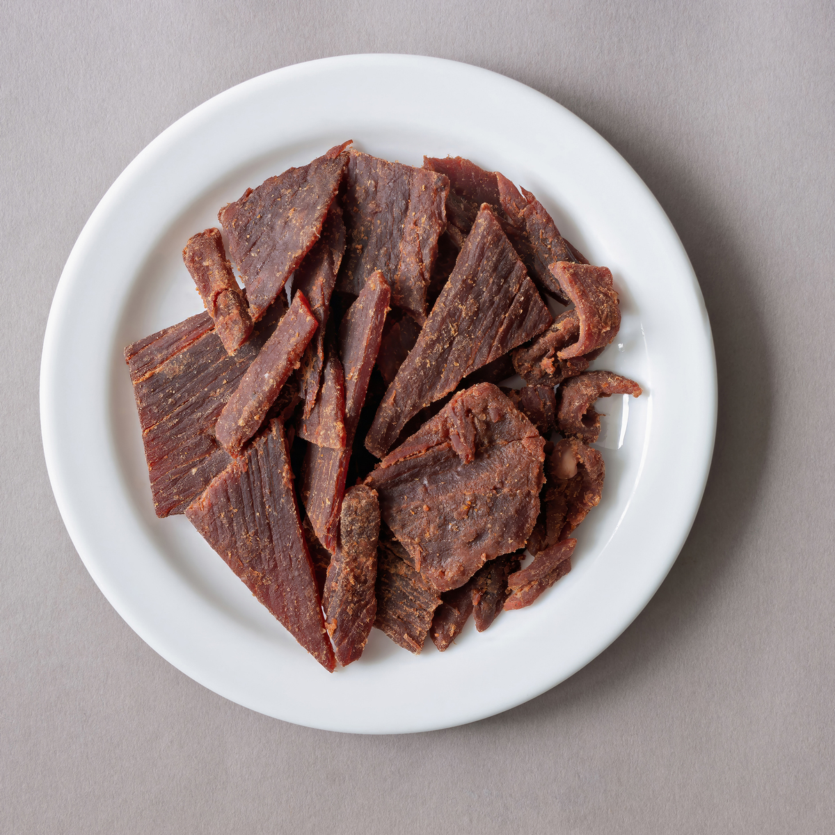 甜辣牛肉干放在白盘上,是肉食爱好者的美味零食选择