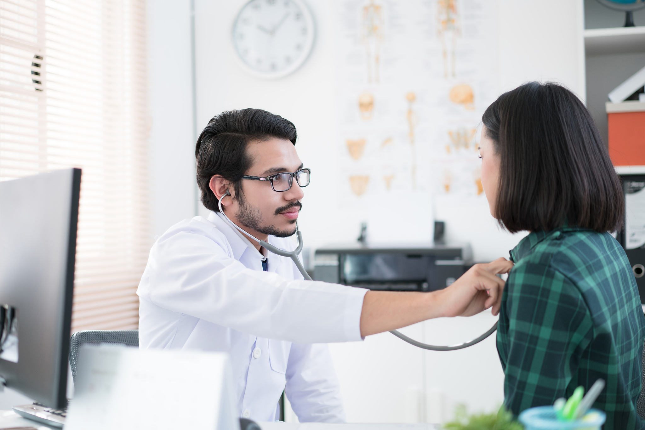 doctors are using a stethoscope to check lungs and heart.