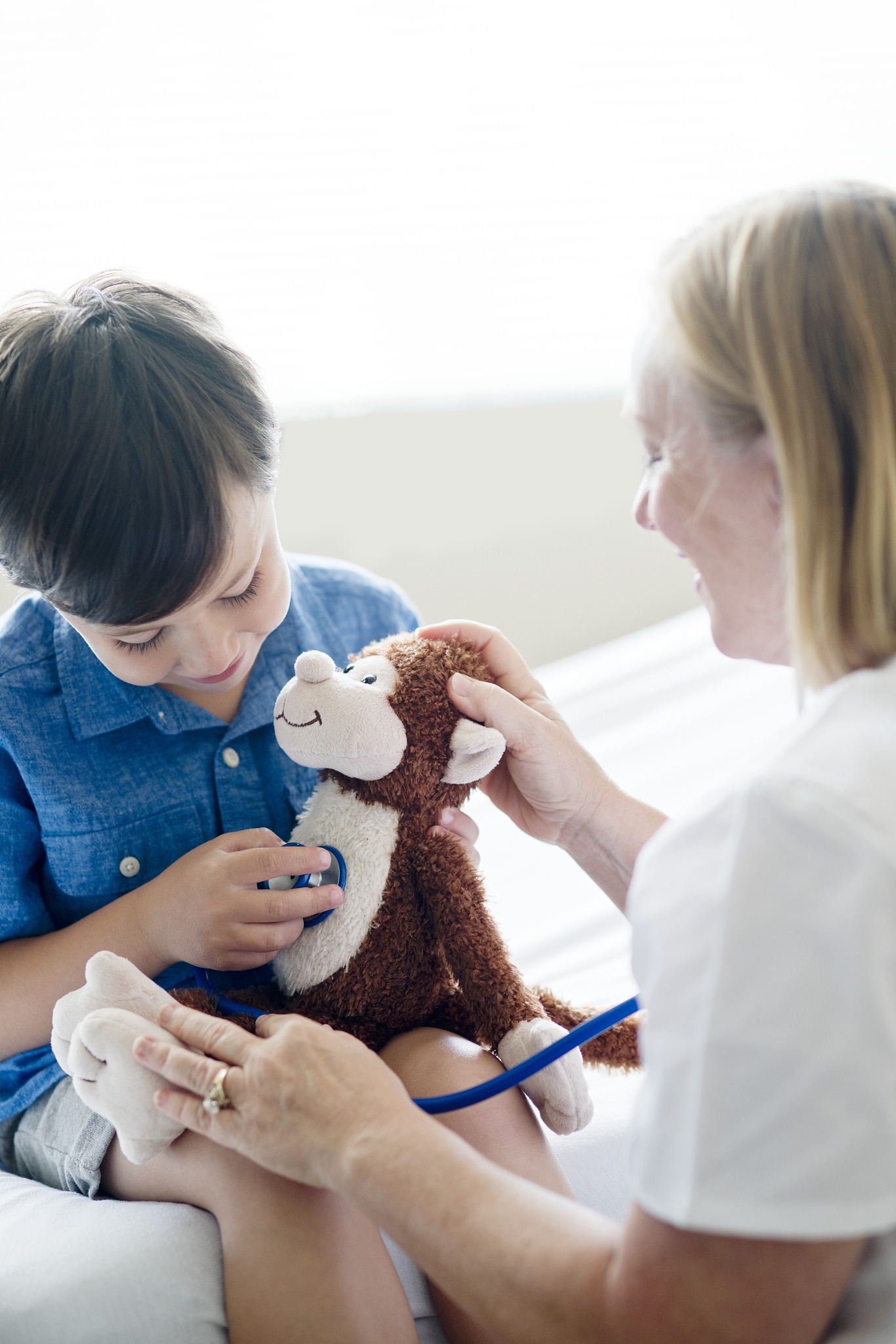 boy playing with stethoscope and teddy bear