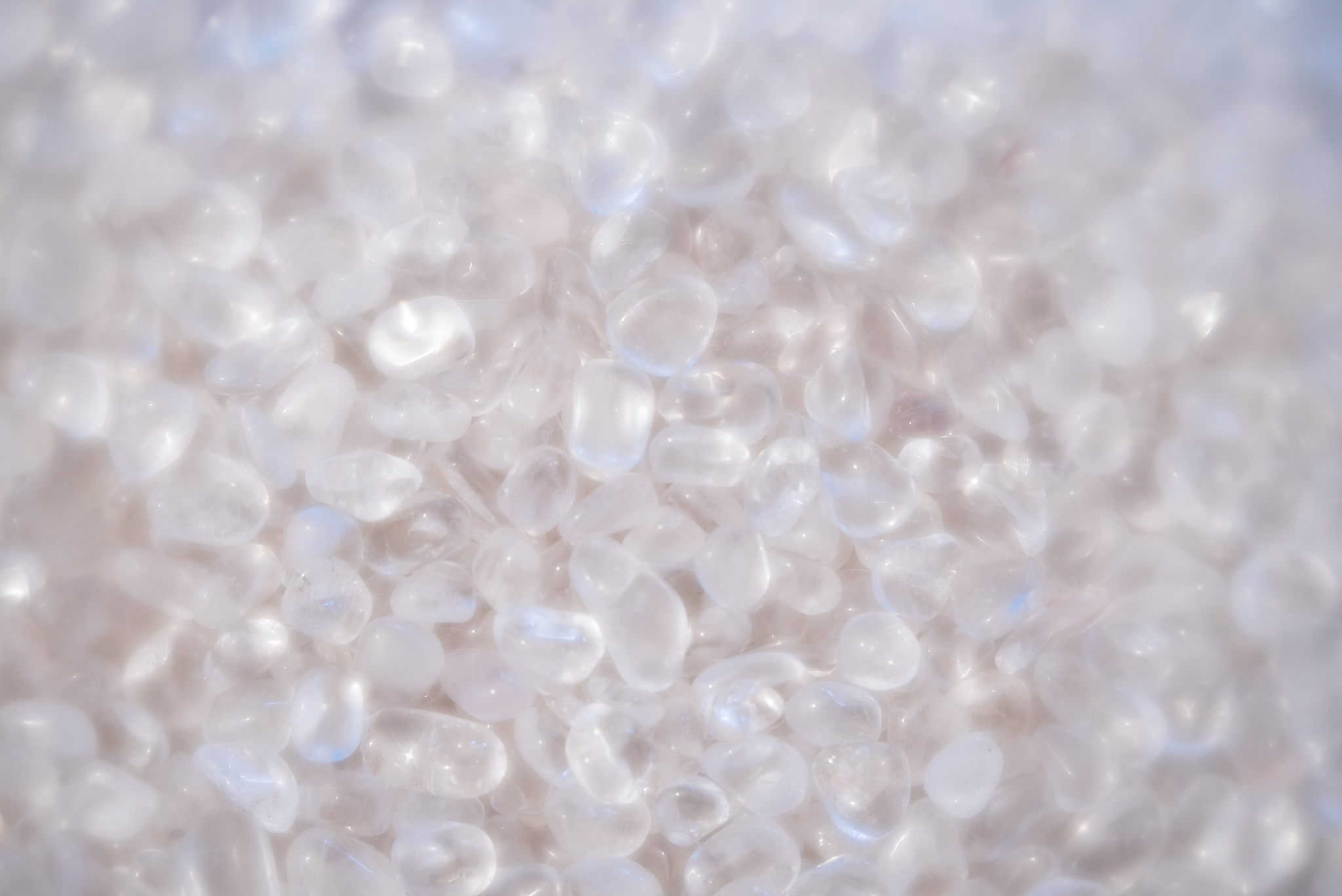 background of small polished quartz and rock crystal stones in a