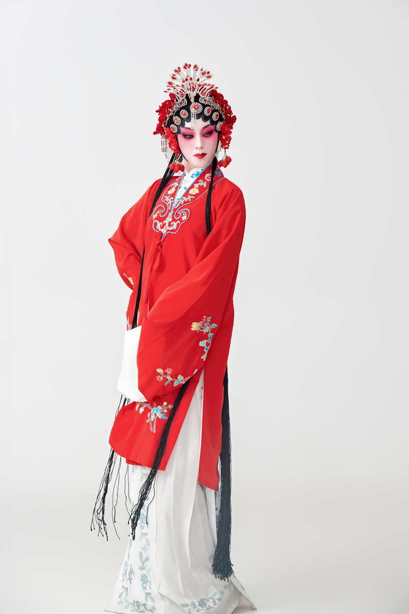 身着红衣的女演员正在表演中国国粹京剧的动作