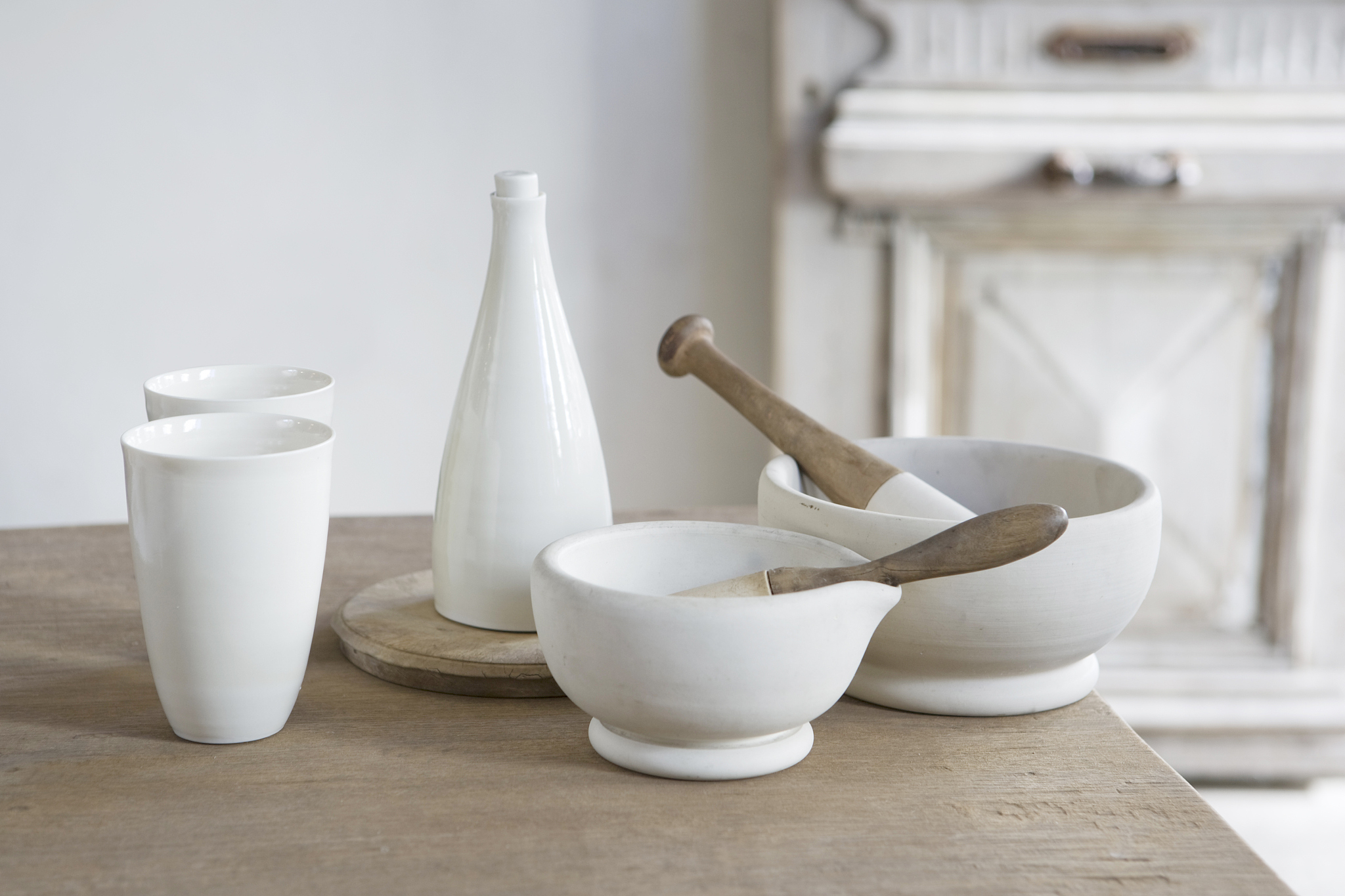pestle and mortars and ceramic cups on a table.