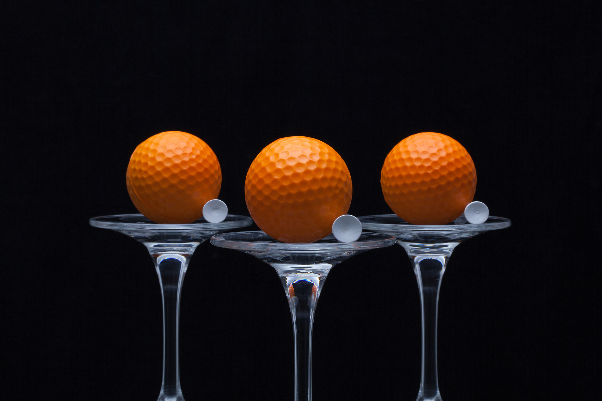three glasses of champagne and golf balls