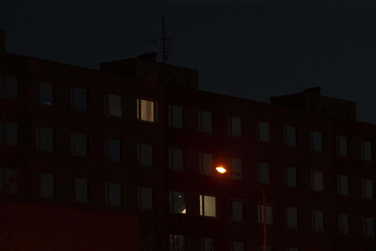 夜晚,宁静的城市景观中,孤零零一扇亮着的窗户,映照着