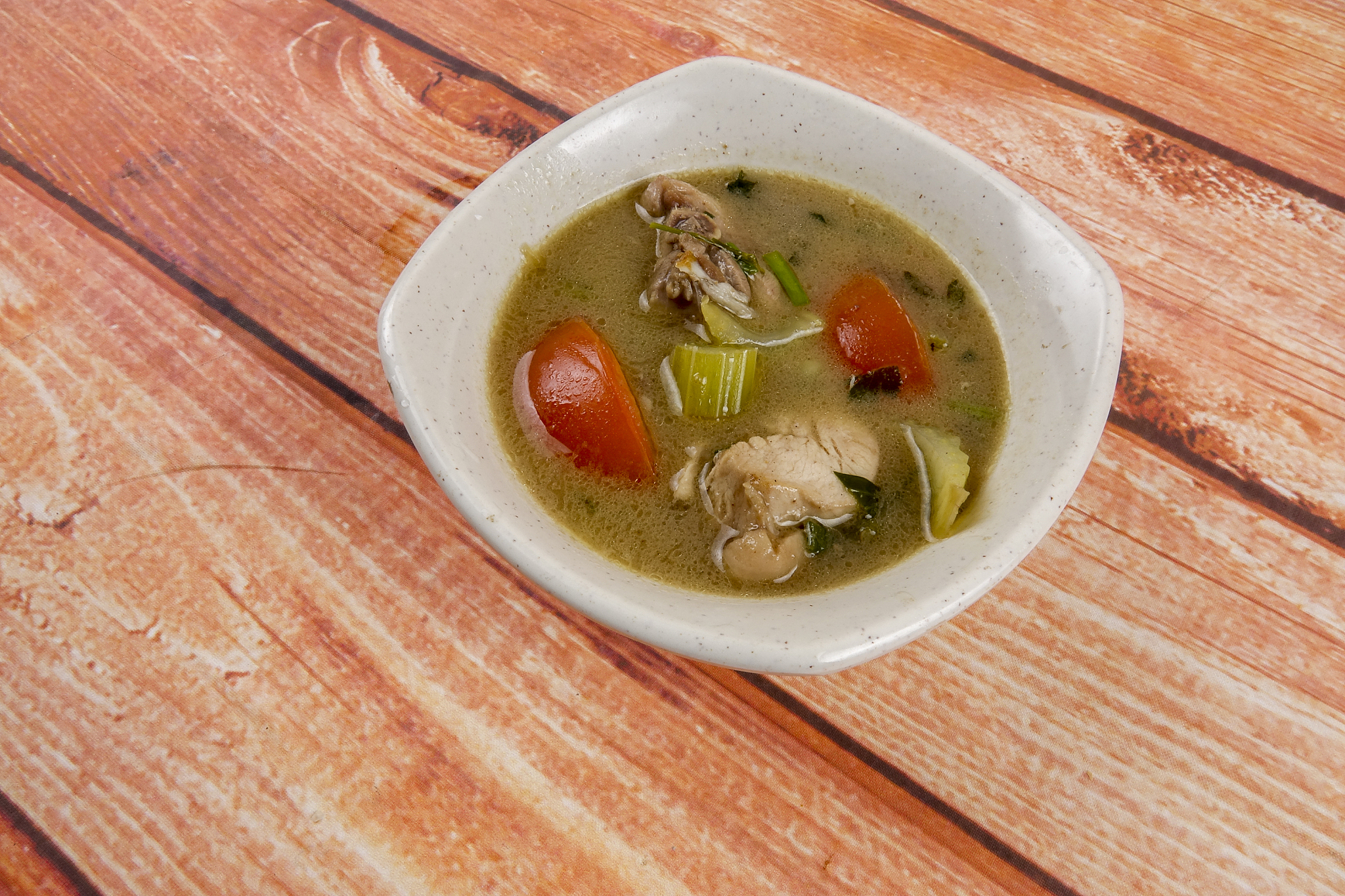 chicken soup on wooden table. top view.