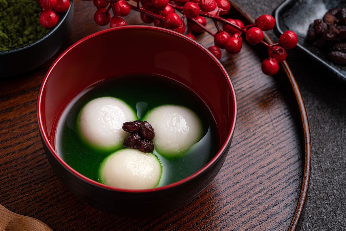 灰色桌上的抹茶大汤圆和抹茶汤.