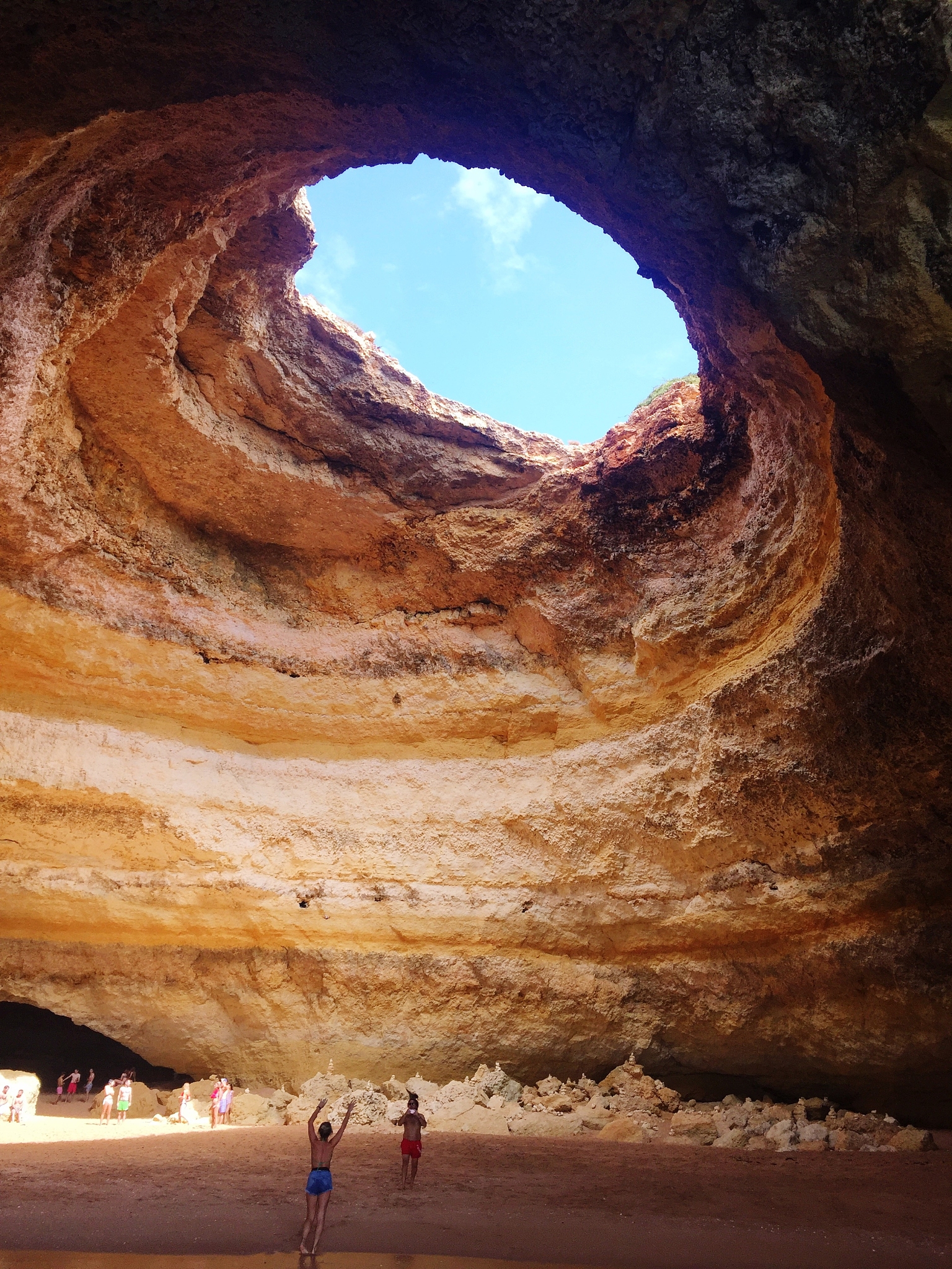 people at beach against rock formation