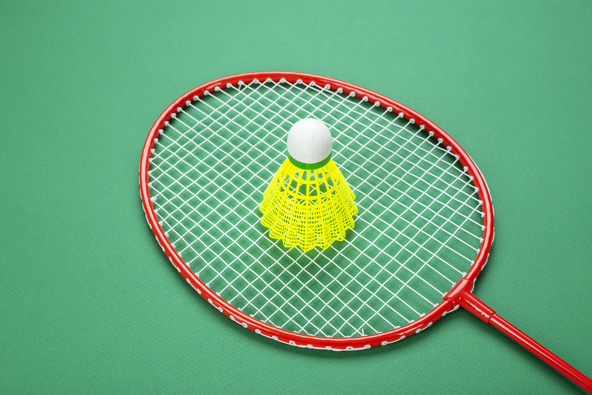 shuttlecock and badminton racket. on a green background.
