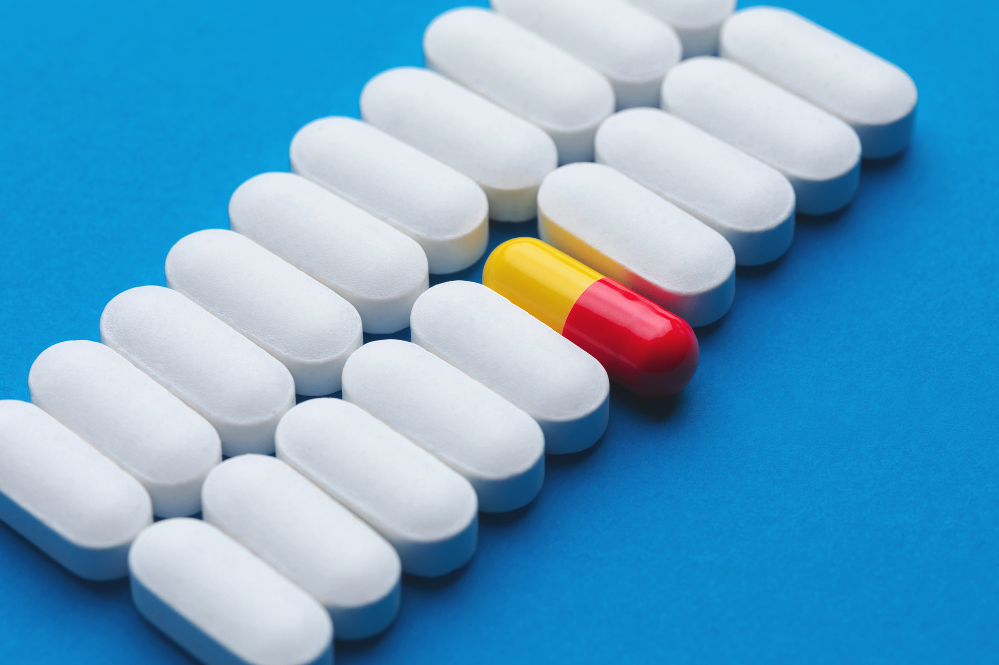 one red pill among white pills. concept of uniqueness