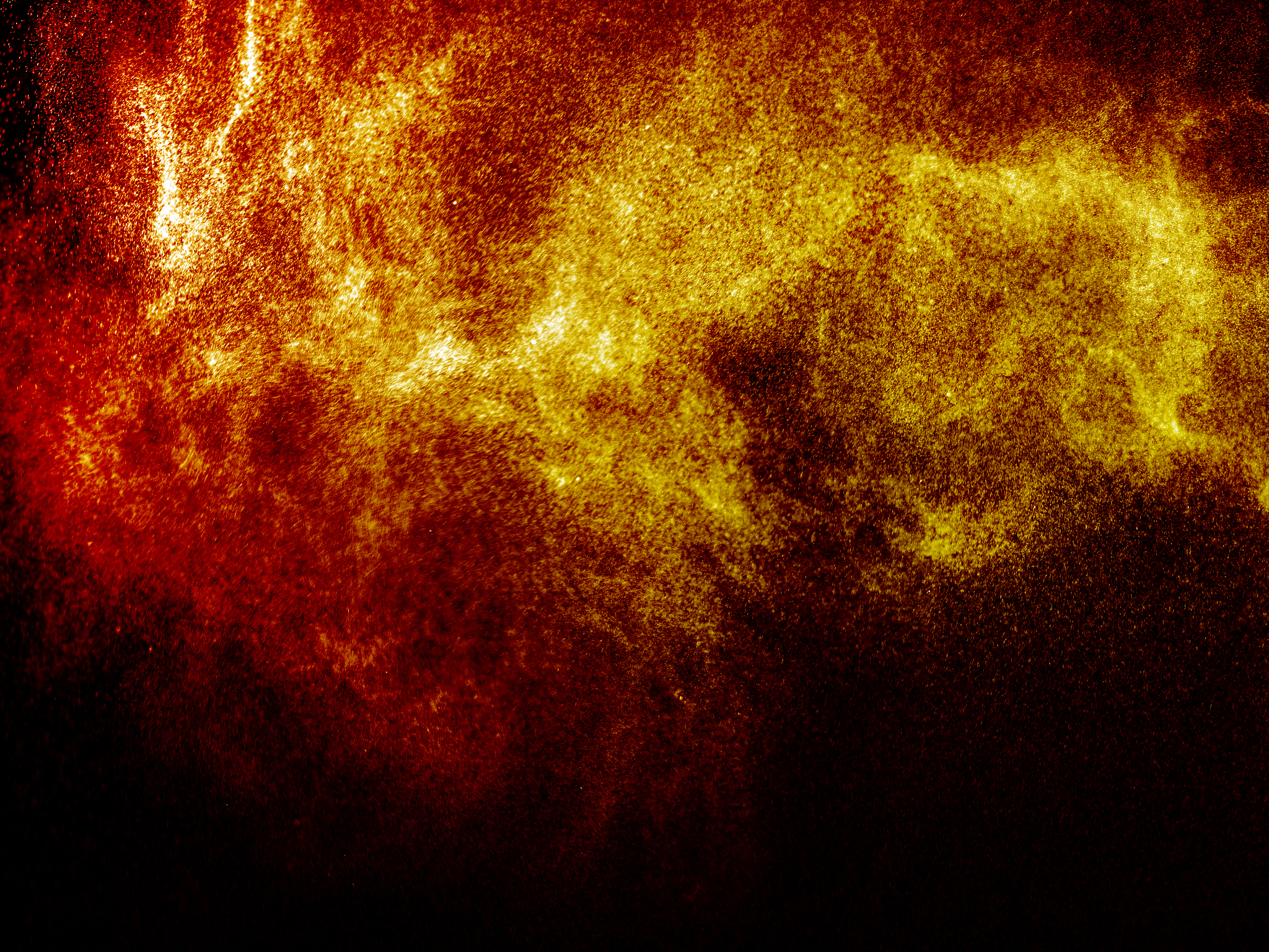 full frame of a jet of flammable liquid particles on fire on a b