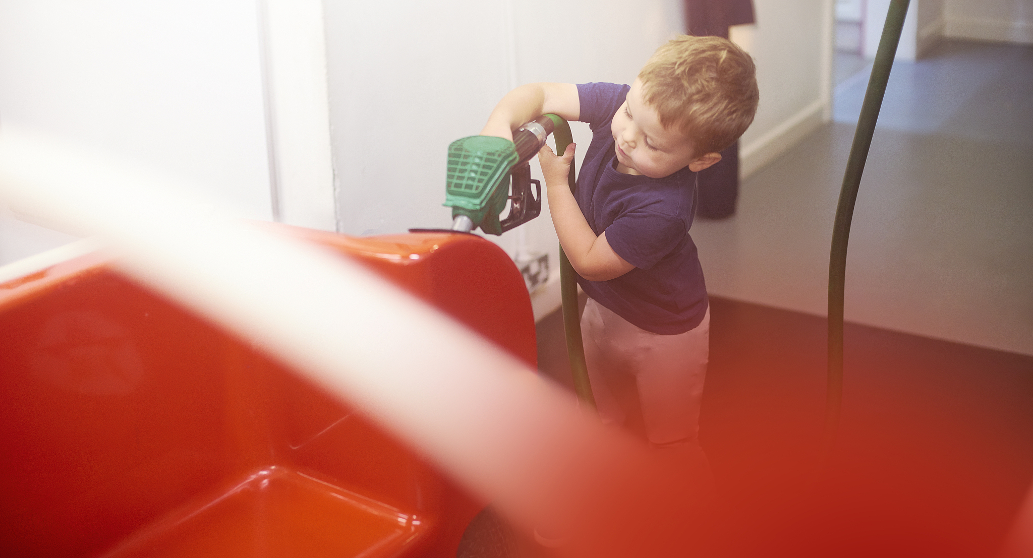 toddler putting petrol in toy car