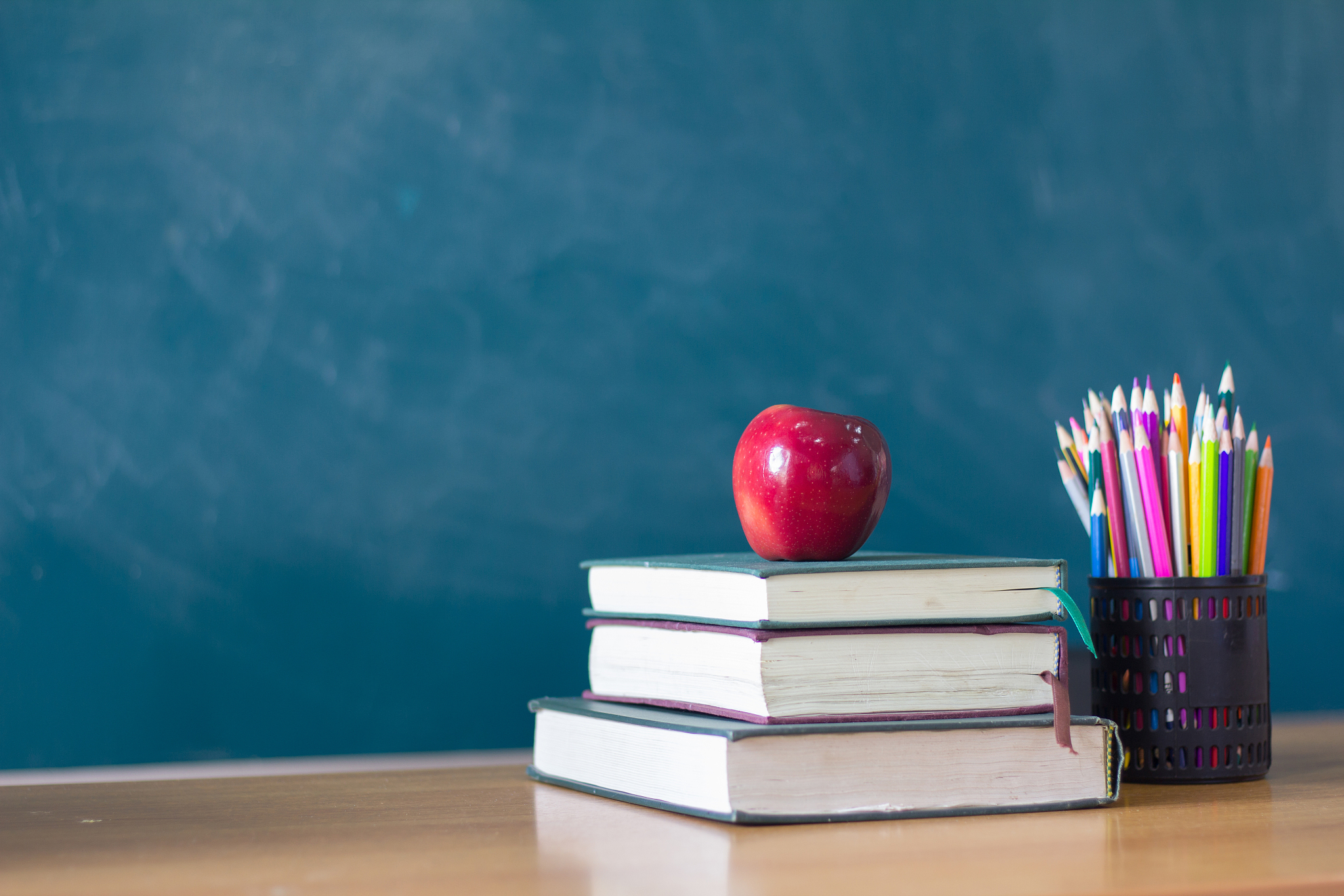 apple puts on a book studying ,the background is blackboard, edu