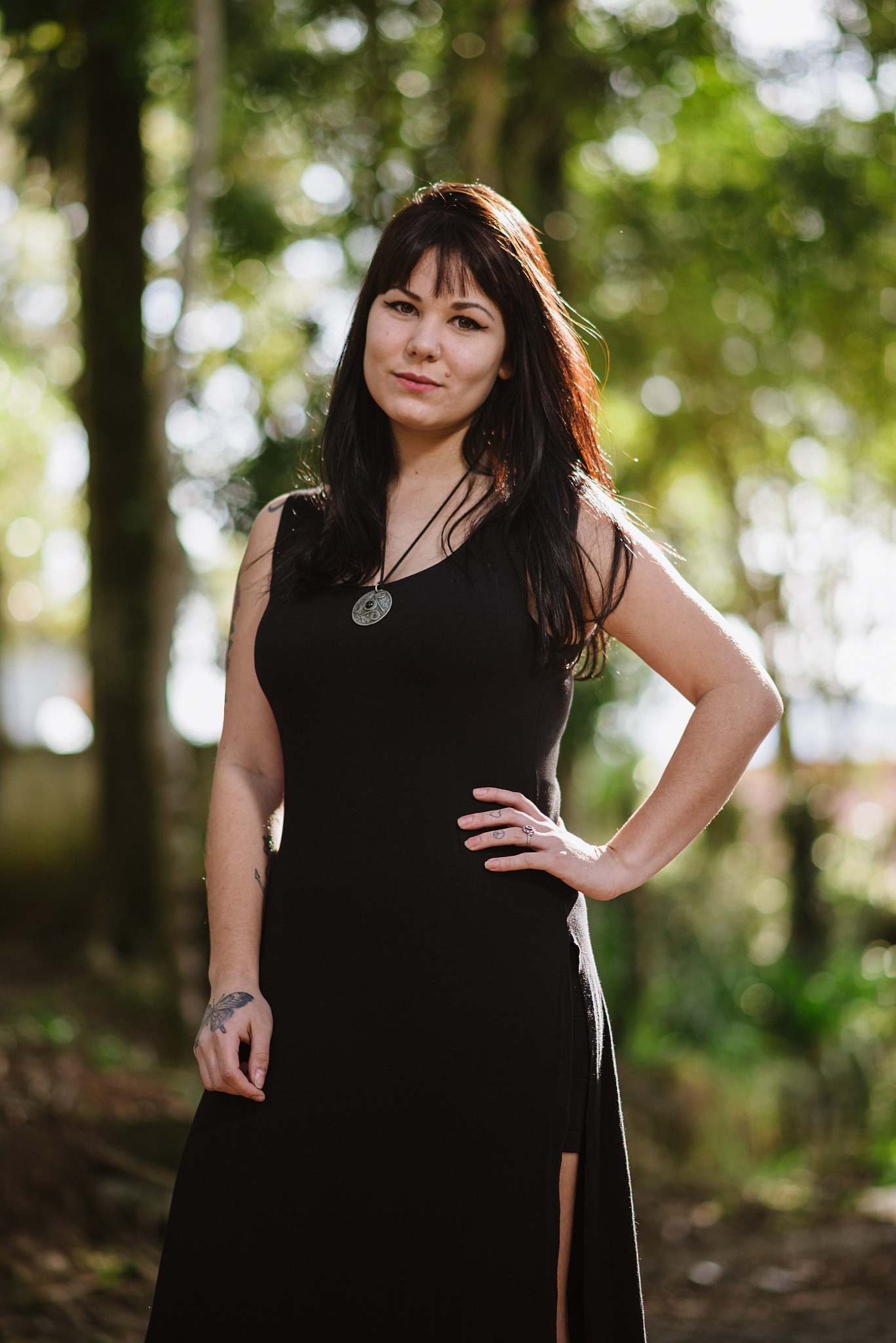 confident young woman with long black dress, countryside
