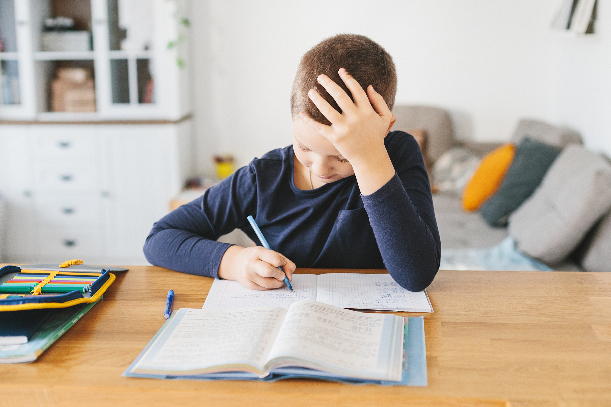 schoolboy doing his homework on desk at home.