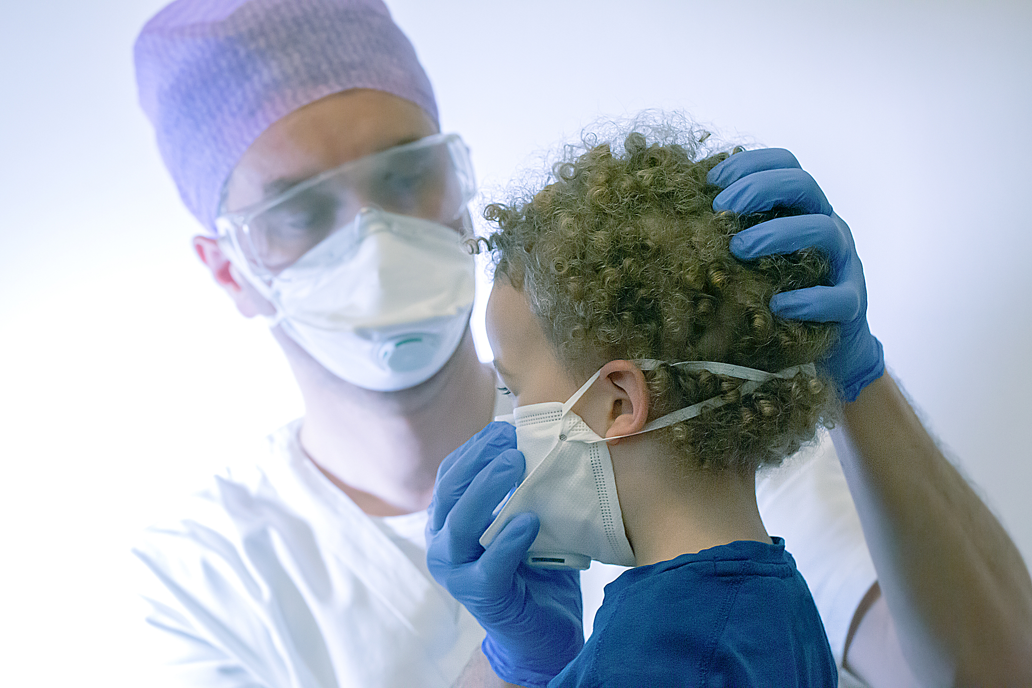 doctor examining girl against white background