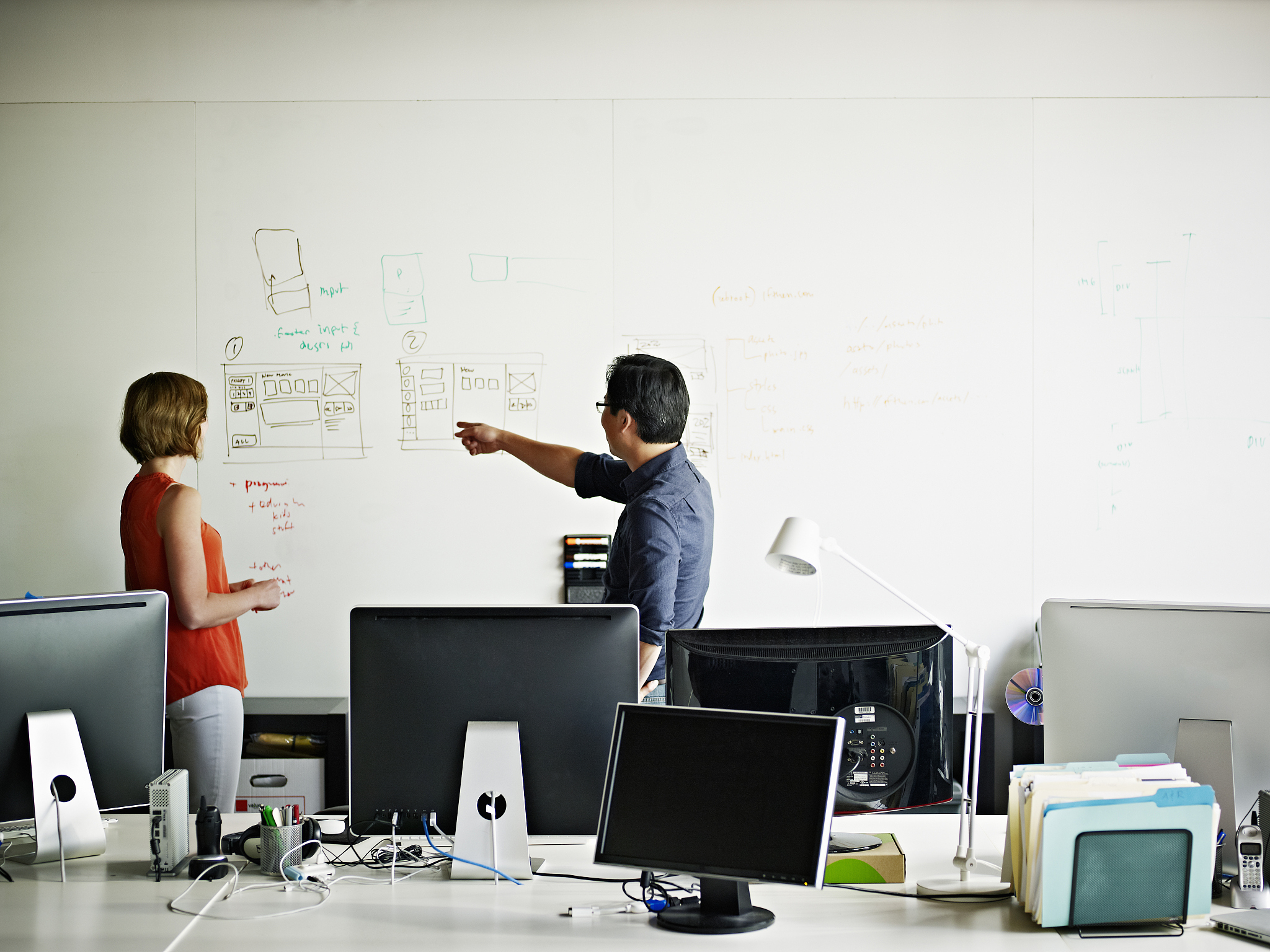two designers in office discussing project