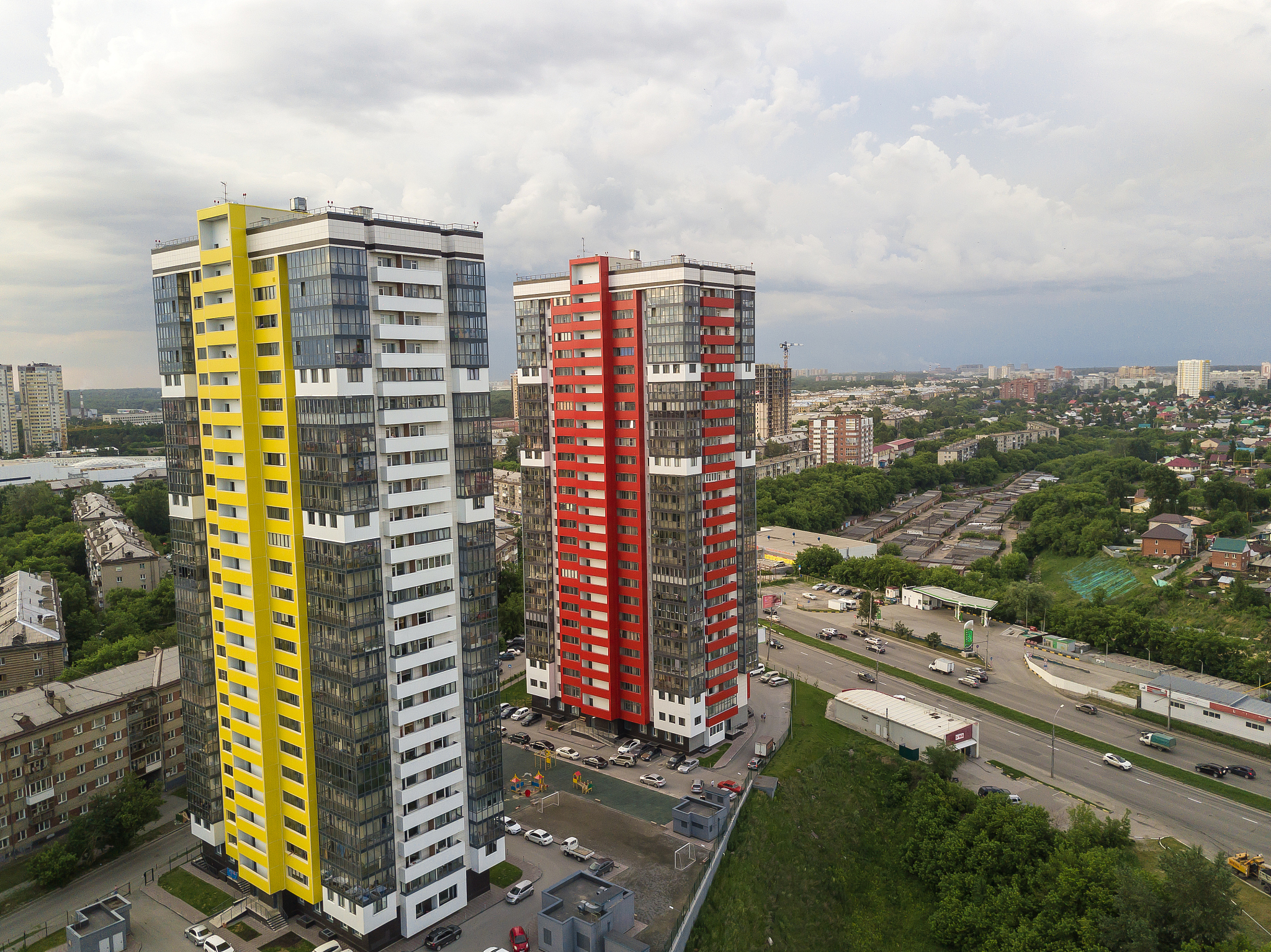 aerial view of landscape with two tall skyscrapers of red and ye