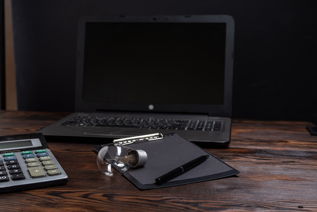 打开的笔记本上有一个灯泡的特写,背景是模糊的笔记本