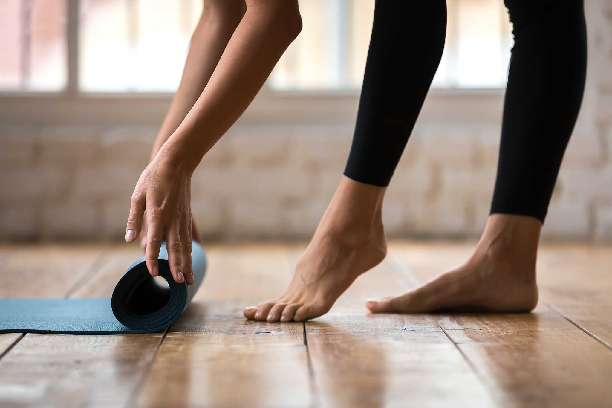 fitness girl unfolding exercise mat for practice