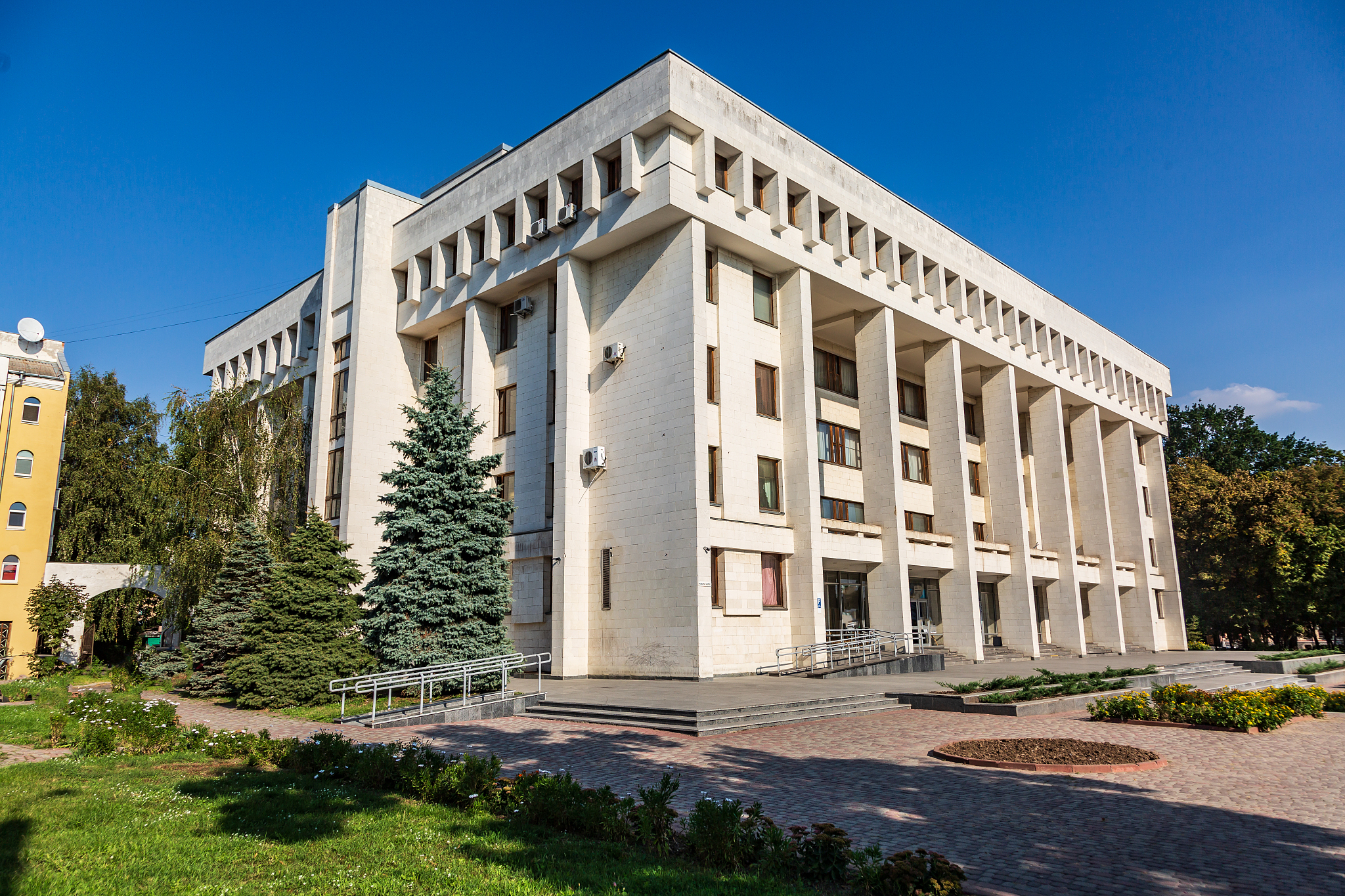 office building in cubism style, entrance square, ramp and blue 