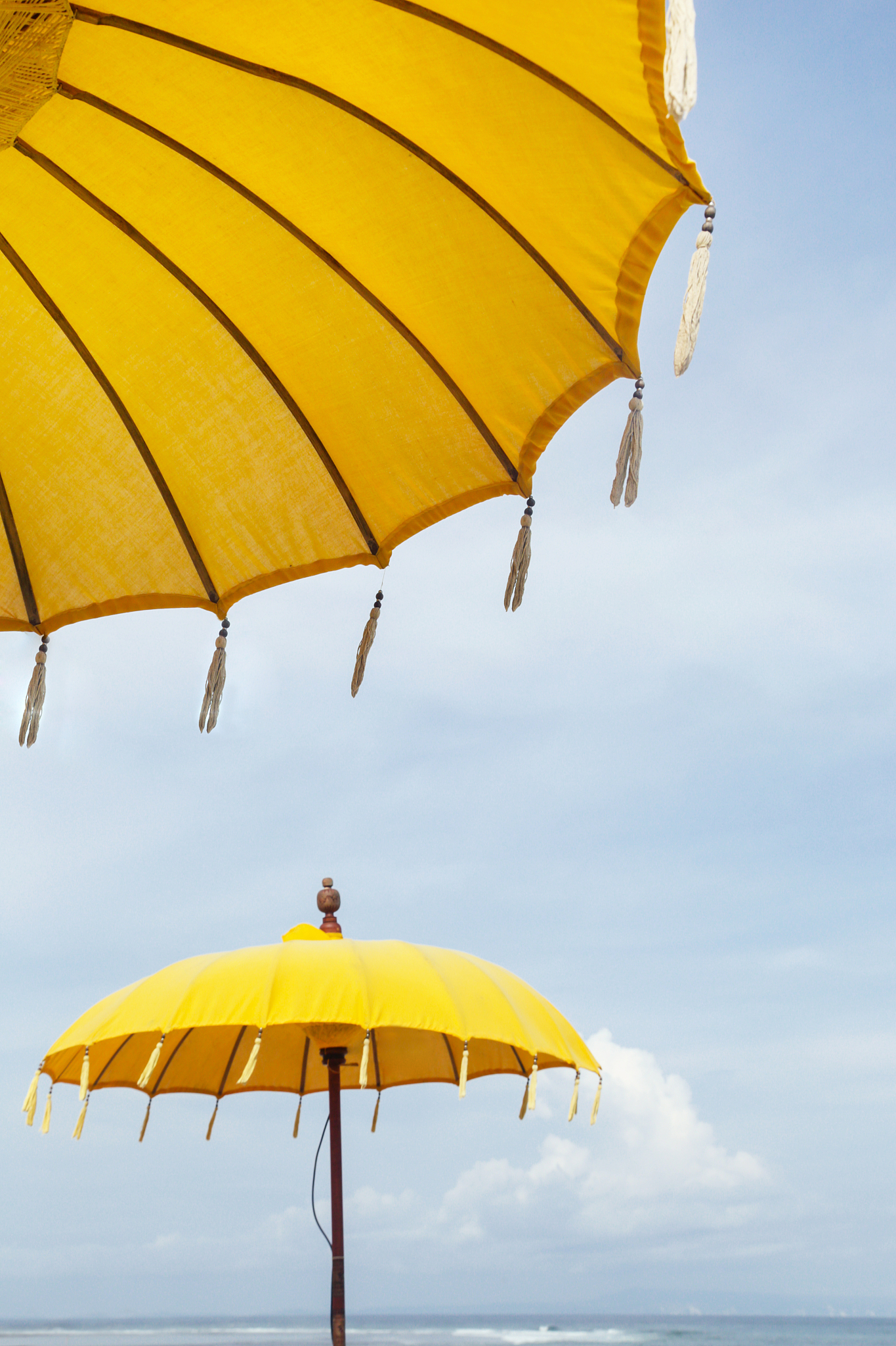yellow color umbrella under the blue sky on the beach, close-up 