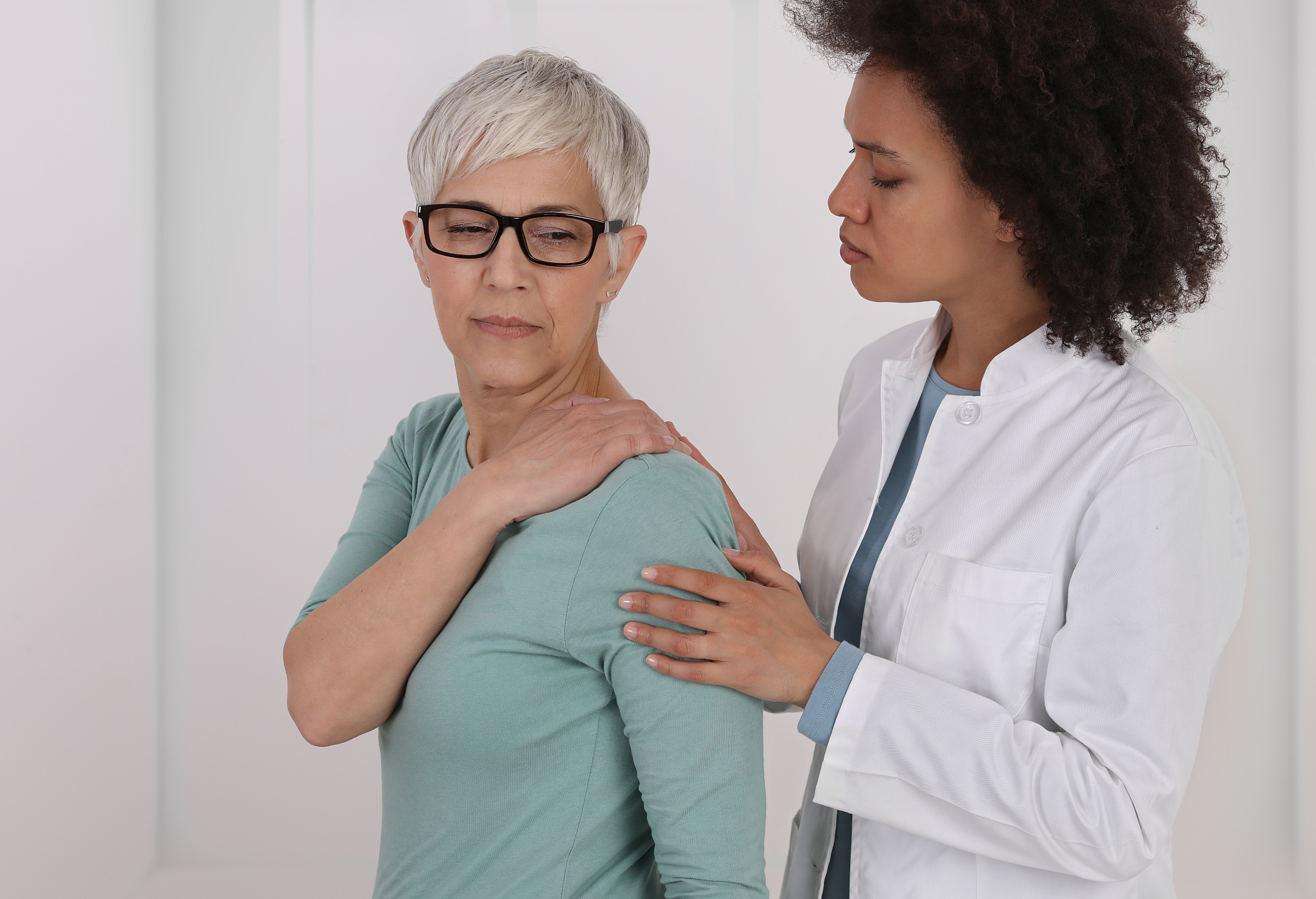 mature woman suffering from back pain during medical exam. chiro