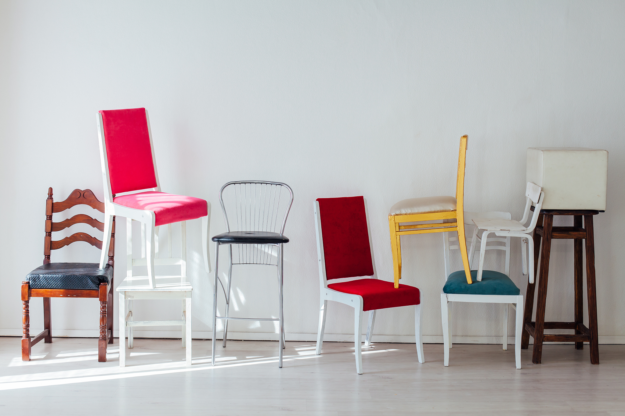 different multicolored chairs in the interior of the white room