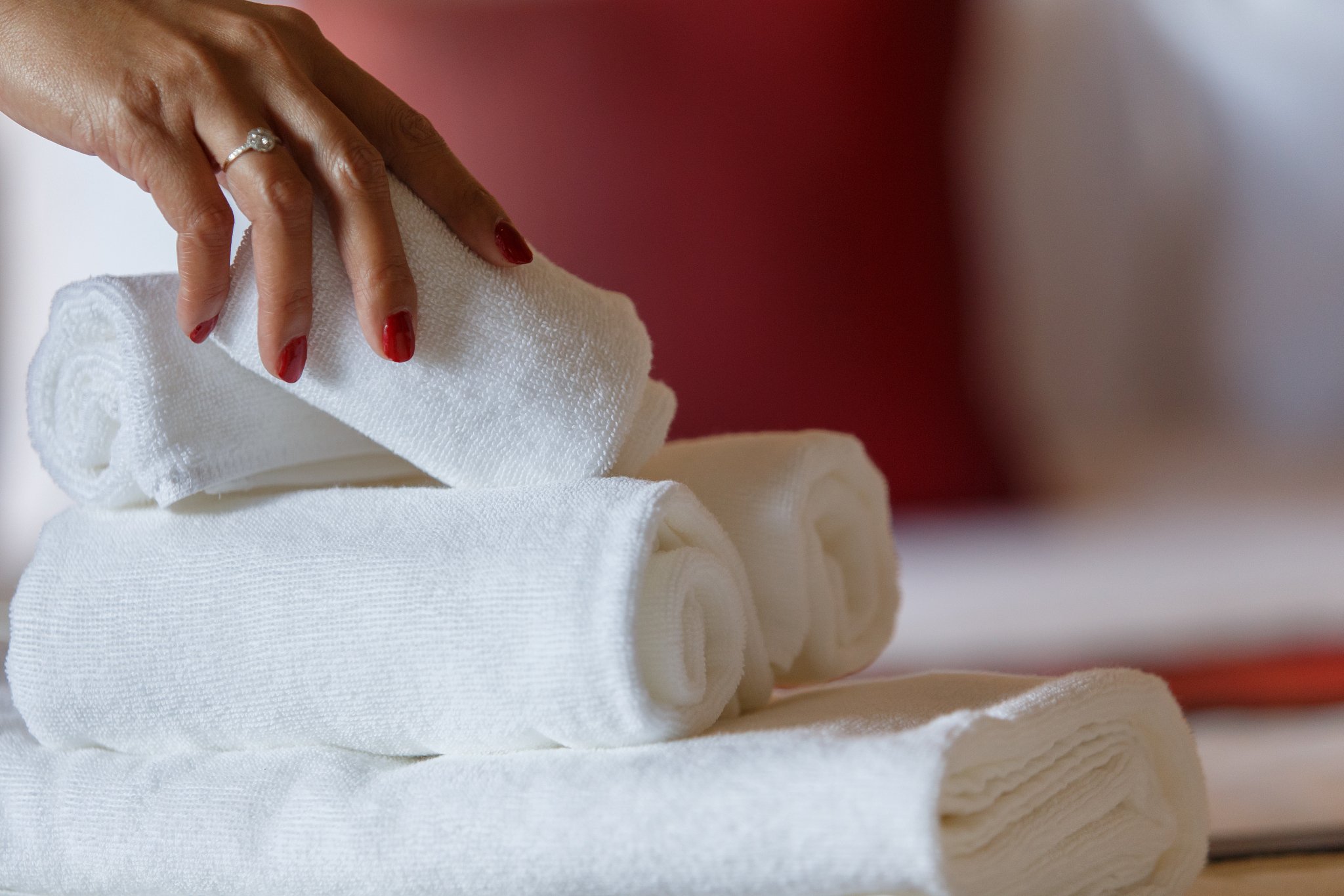 set towels on bedhand. woman pick up white towels in hotel.