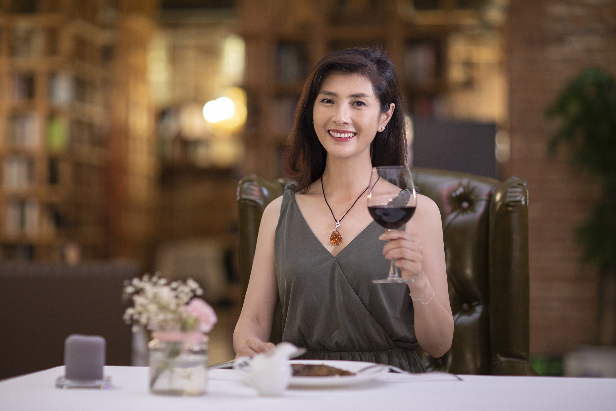 优雅女士在餐厅品尝红酒
