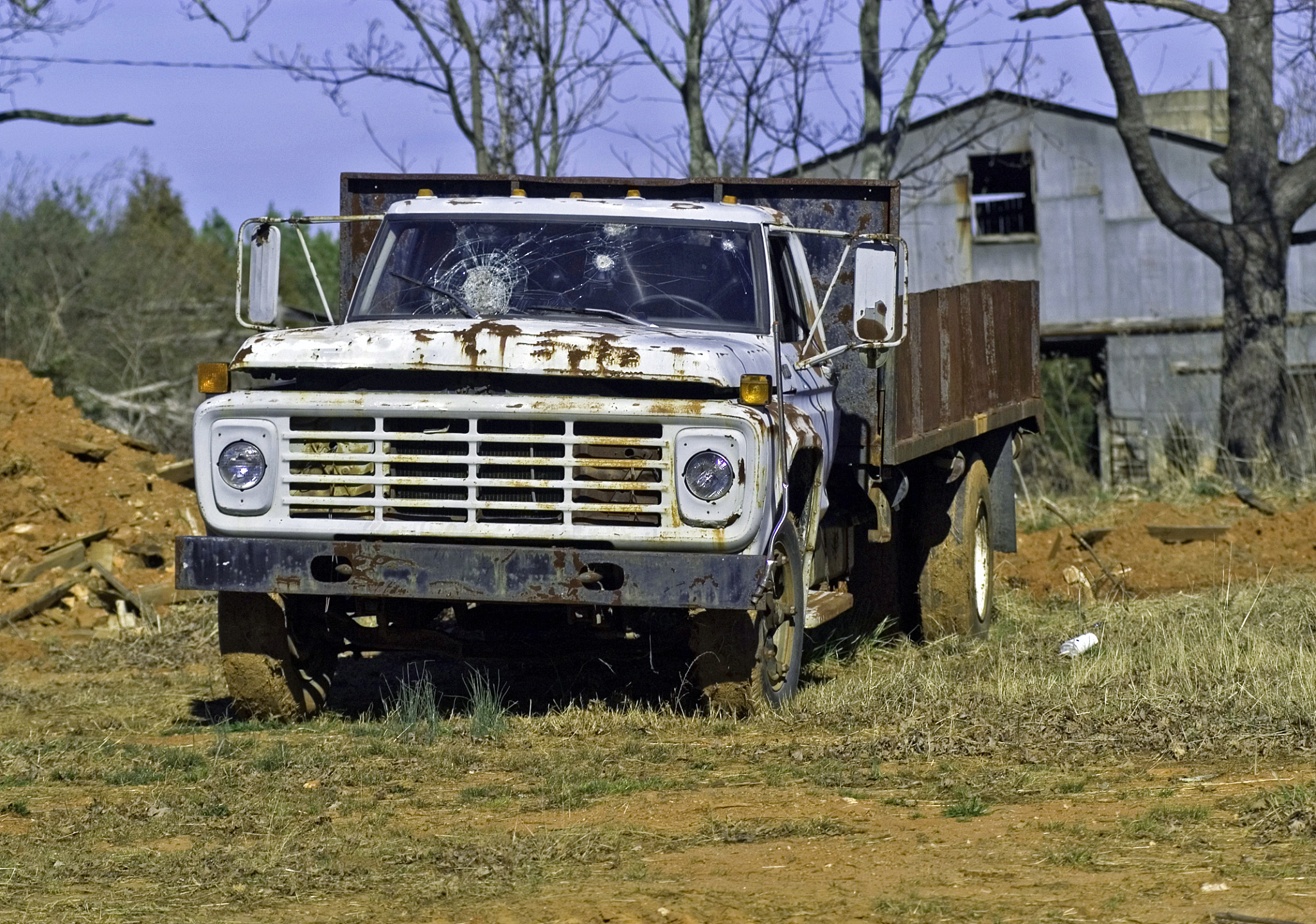 rusted truck in front of barn
