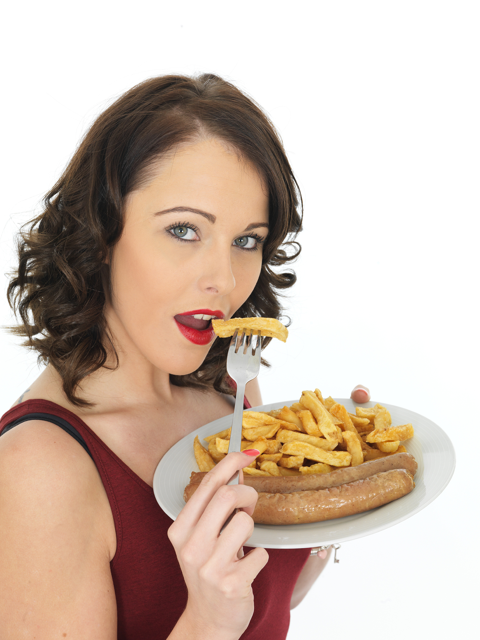 young woman eating jumbo sausage and chips with a fork