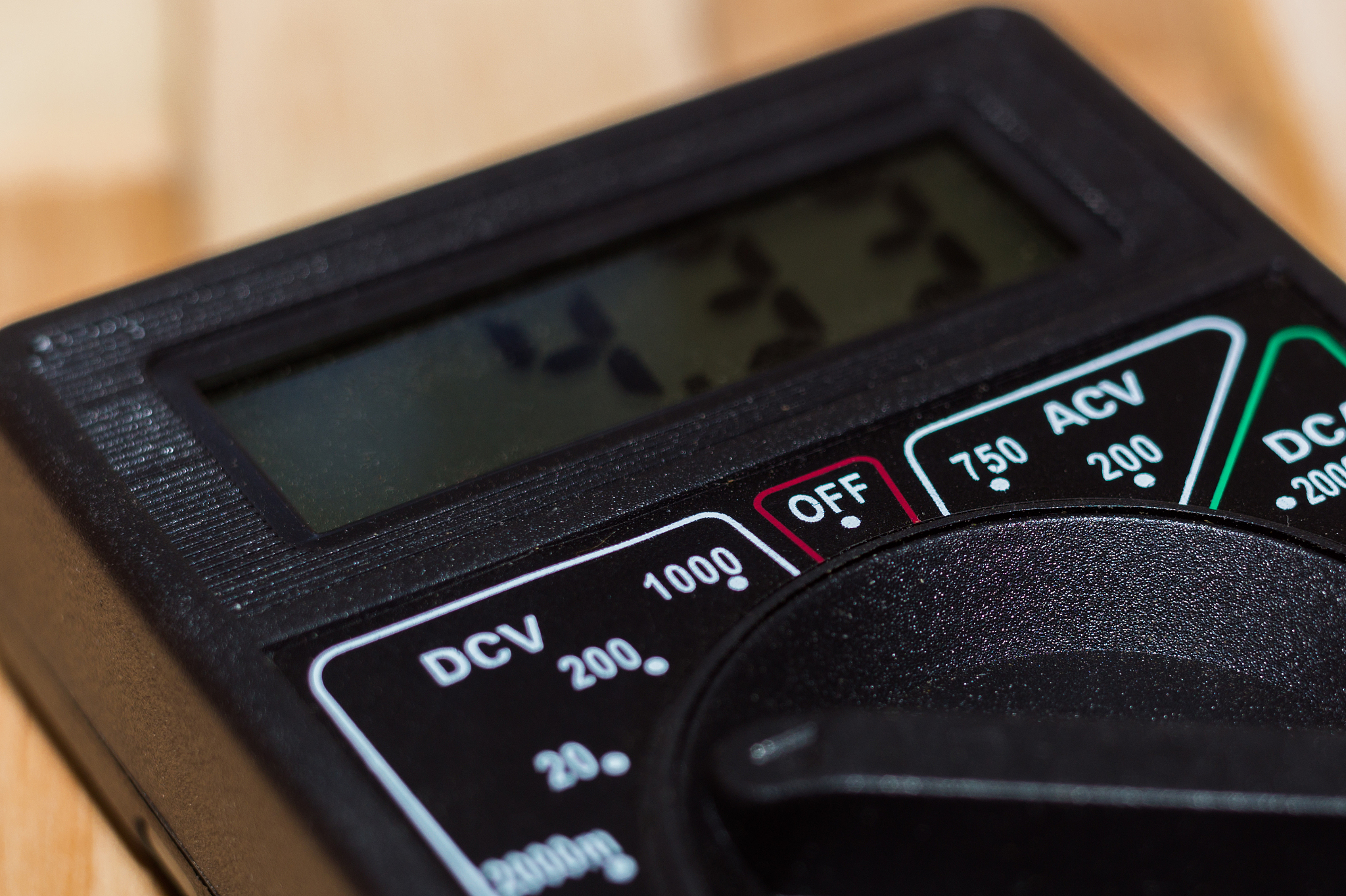 digital measuring multimeter on wooden floor. it shows 4.33v or 