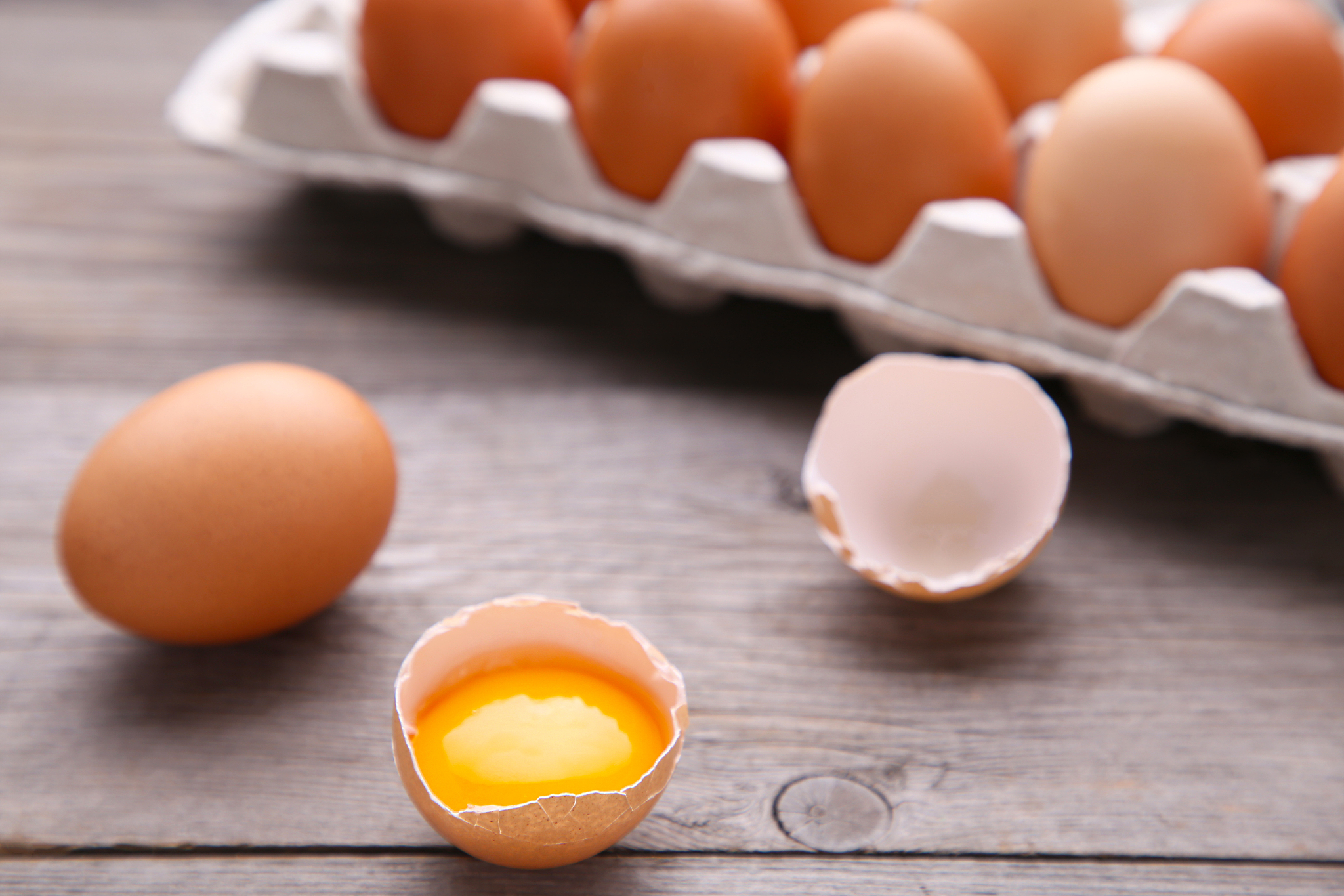 chicken egg is half broken among other eggs. chicken eggs in con
