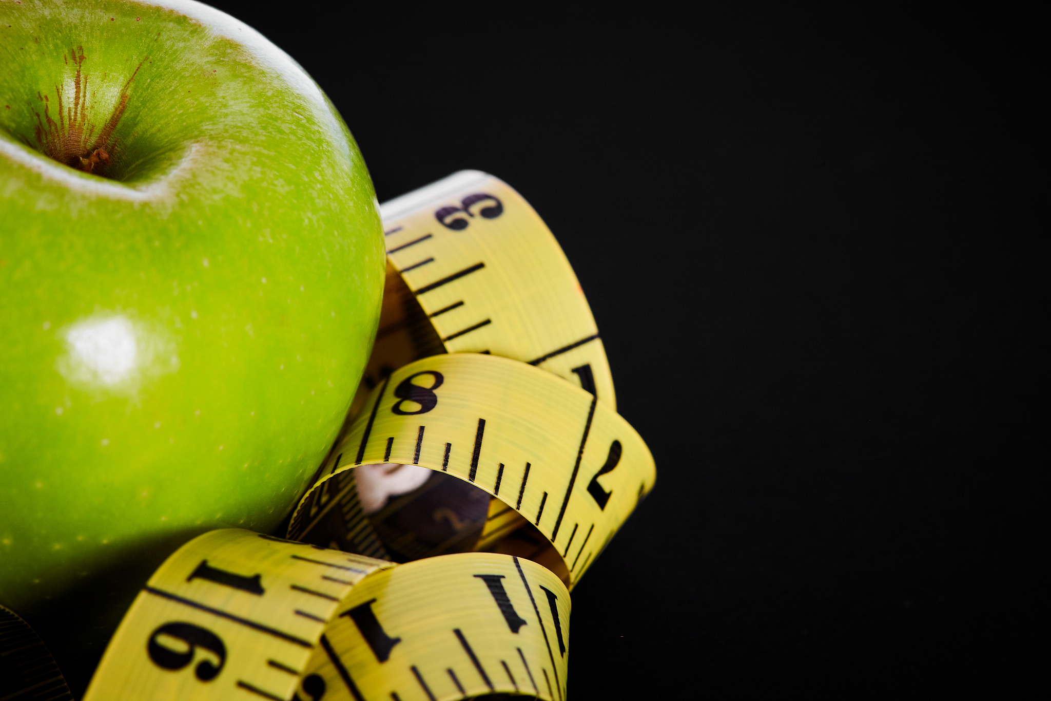 shiny green apple with measuring tape