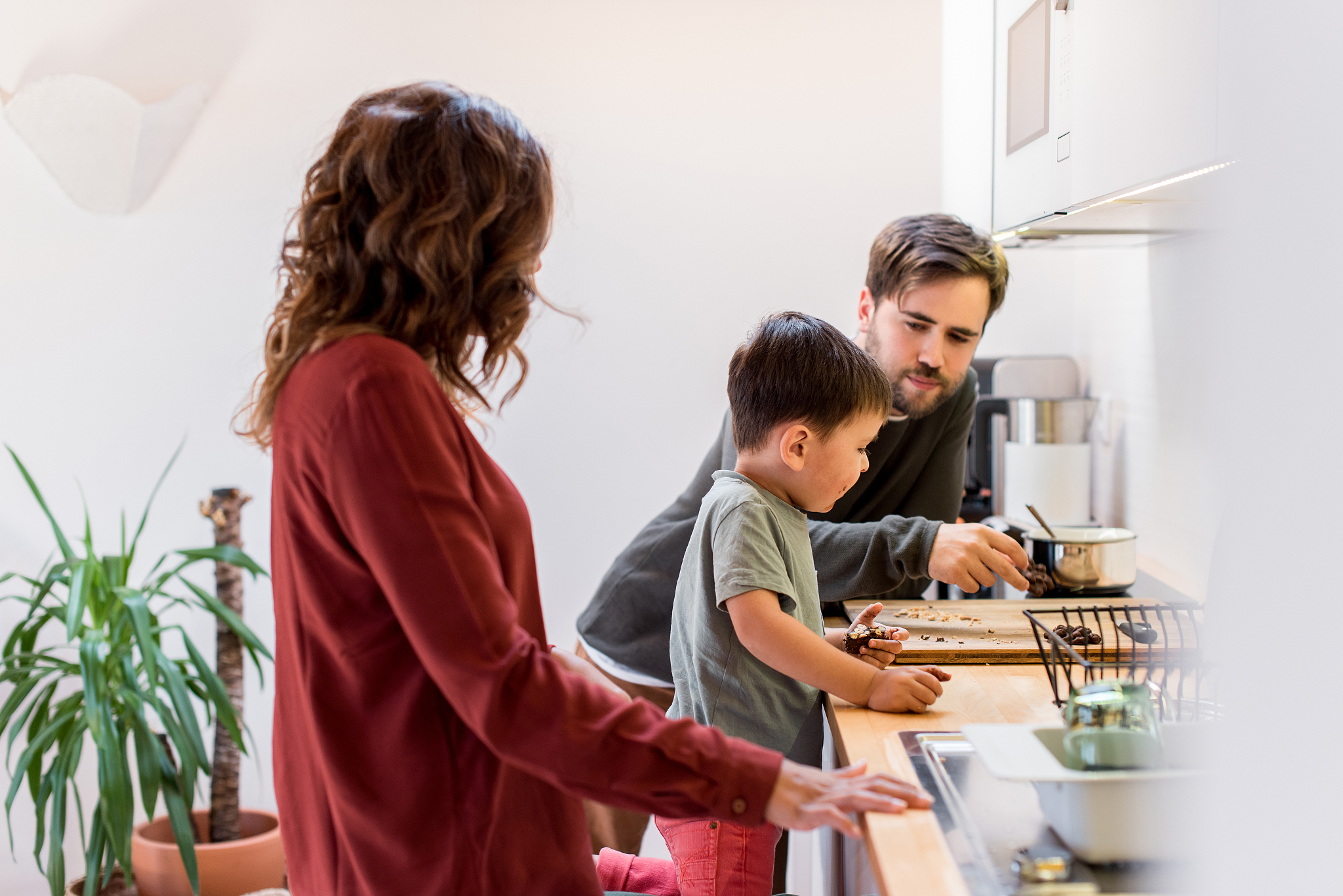 parents with son preparing food at home
