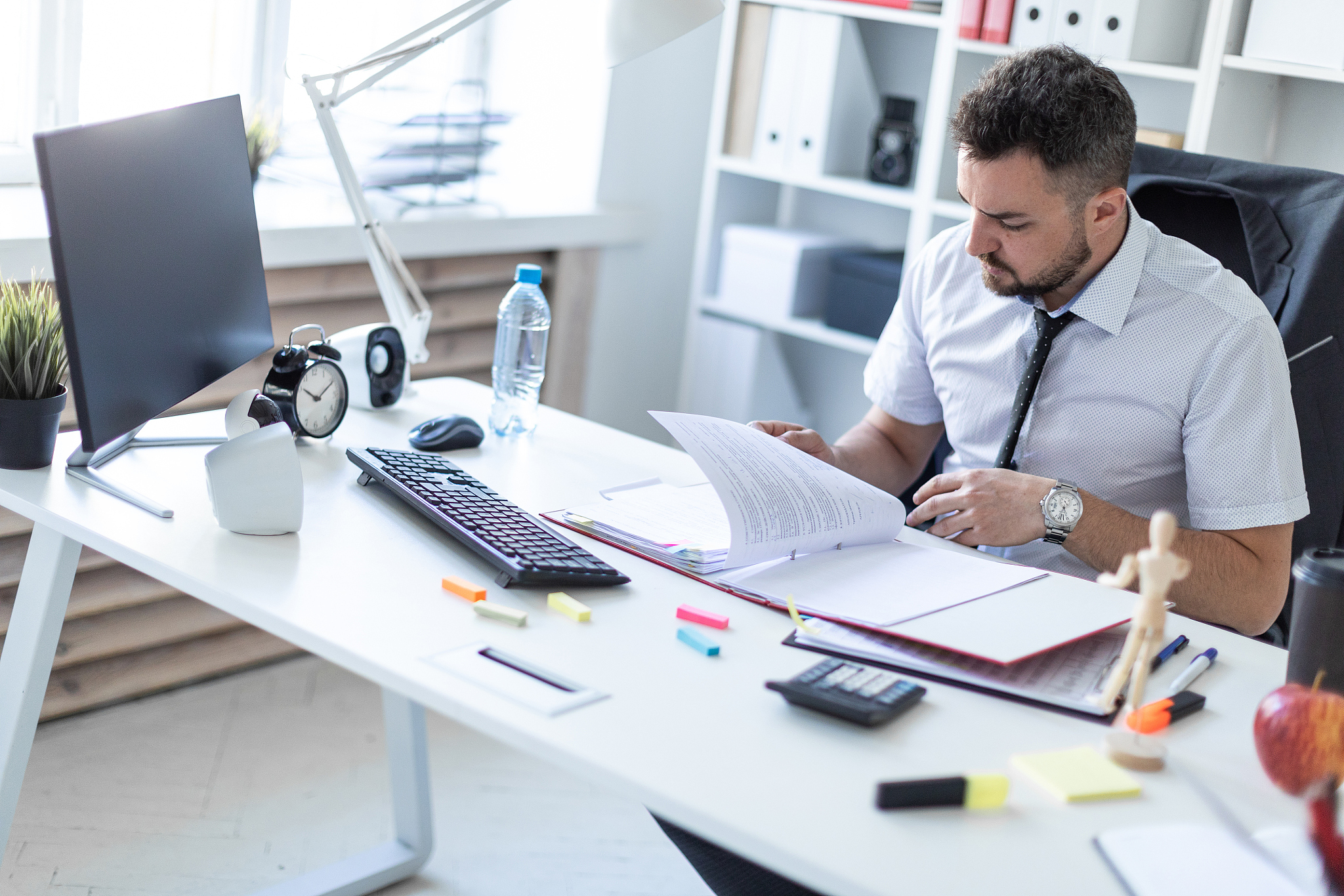 a man is sitting in the office and scrolls through the documents