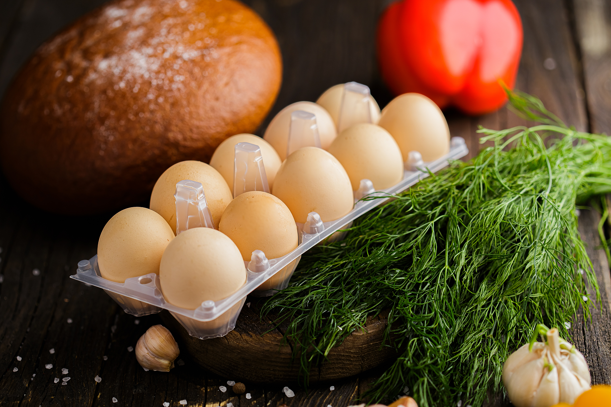 chicken eggs in a package on a wooden board, spices and coarse s