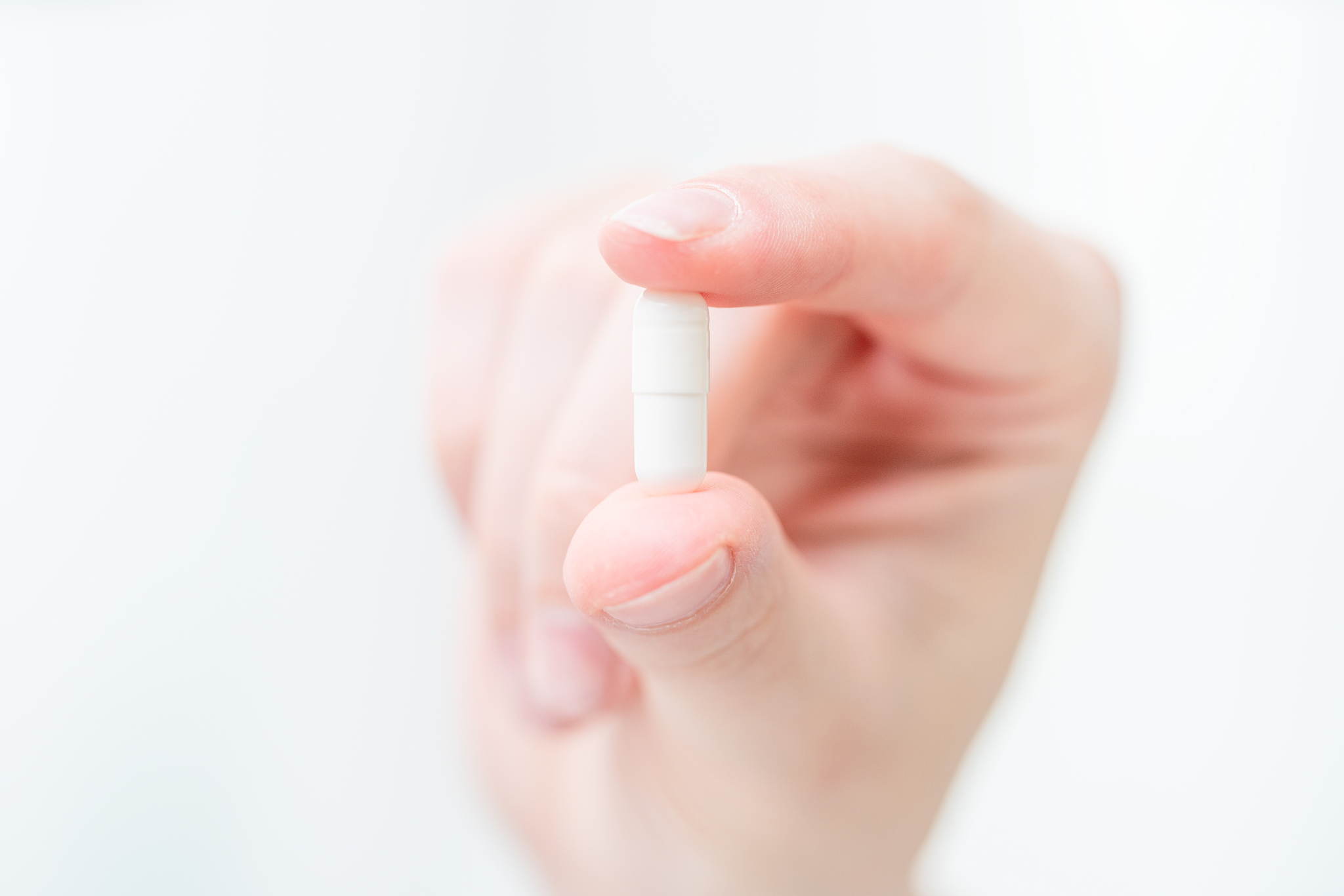white pill in a female hand