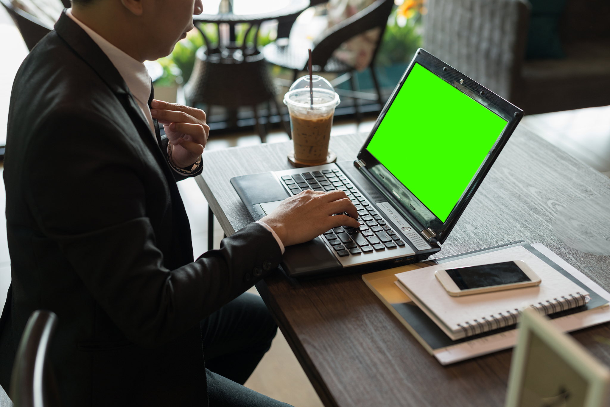 asian young businessman working on laptop with blank green scree