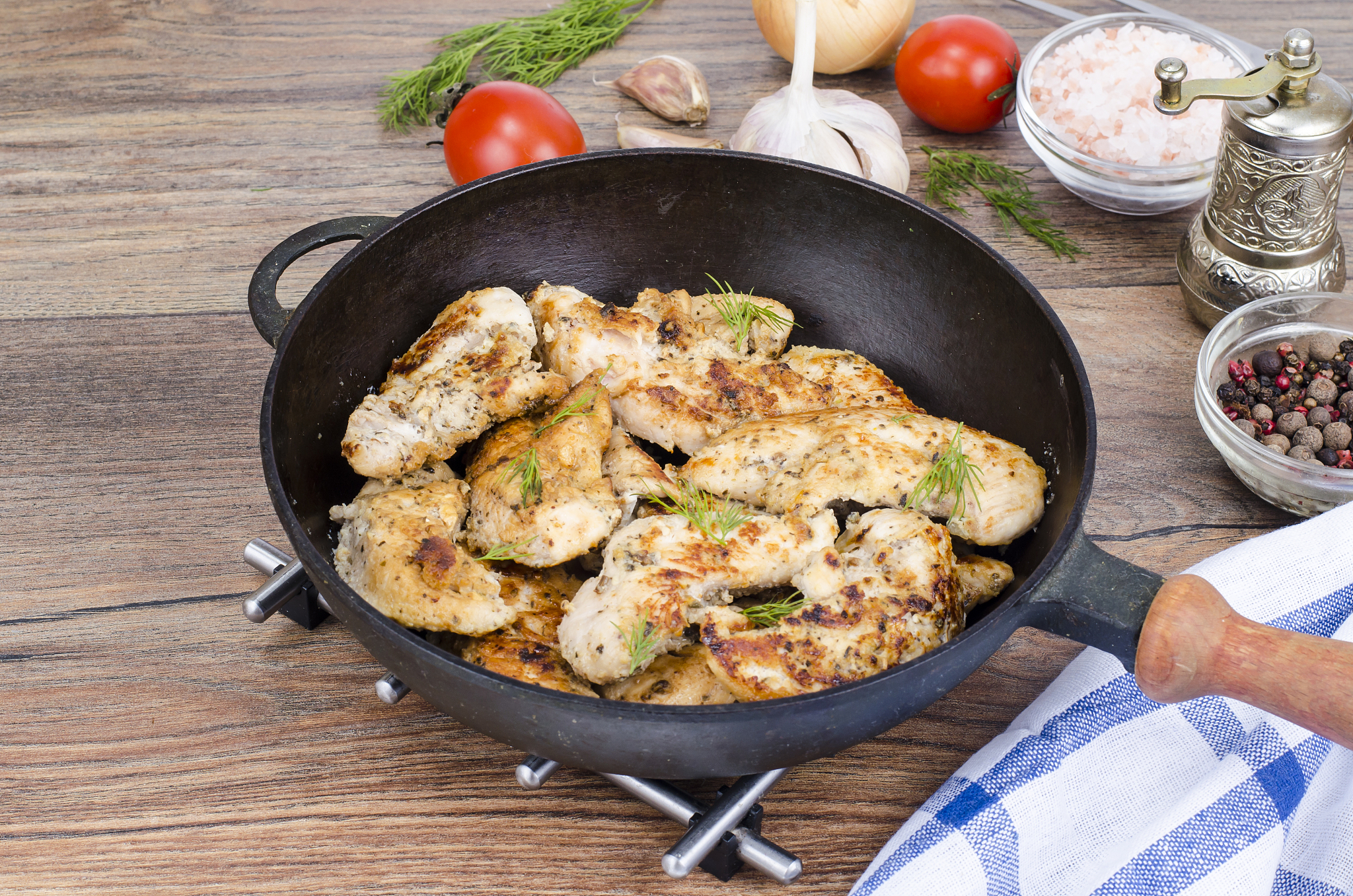 pan with fried chicken pieces, wooden background