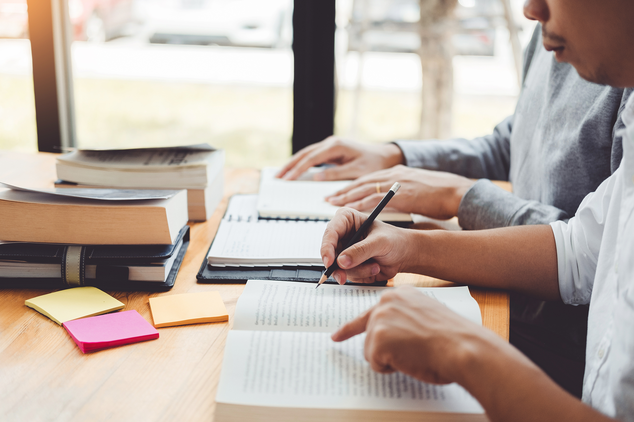 high school or college students studying and reading together in