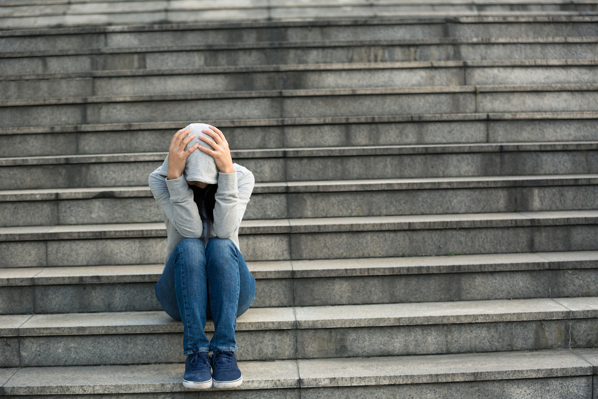 upset woman sitting alone in city stairs
