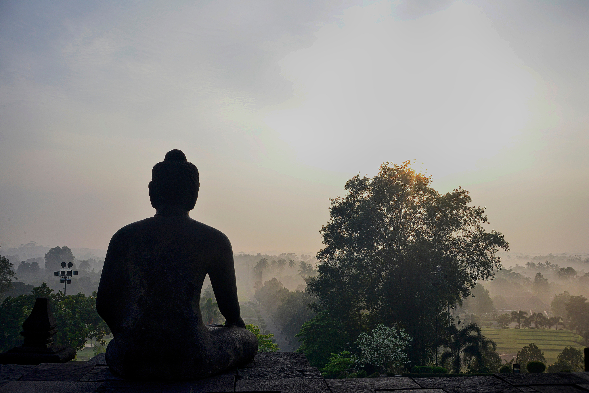 statue outside temple in front of trees against sky